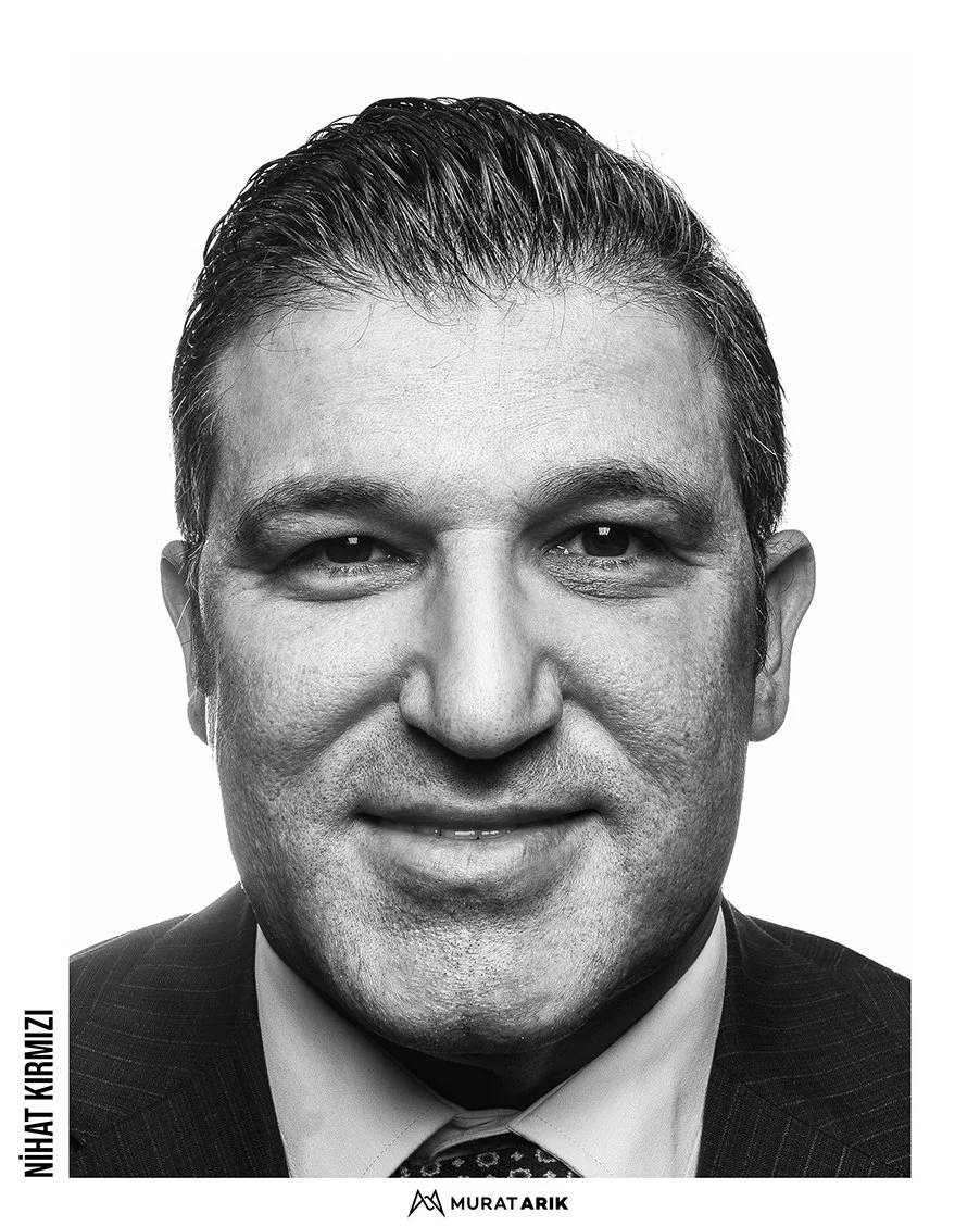 Black and white headshot of a smiling man in a suit and tie.