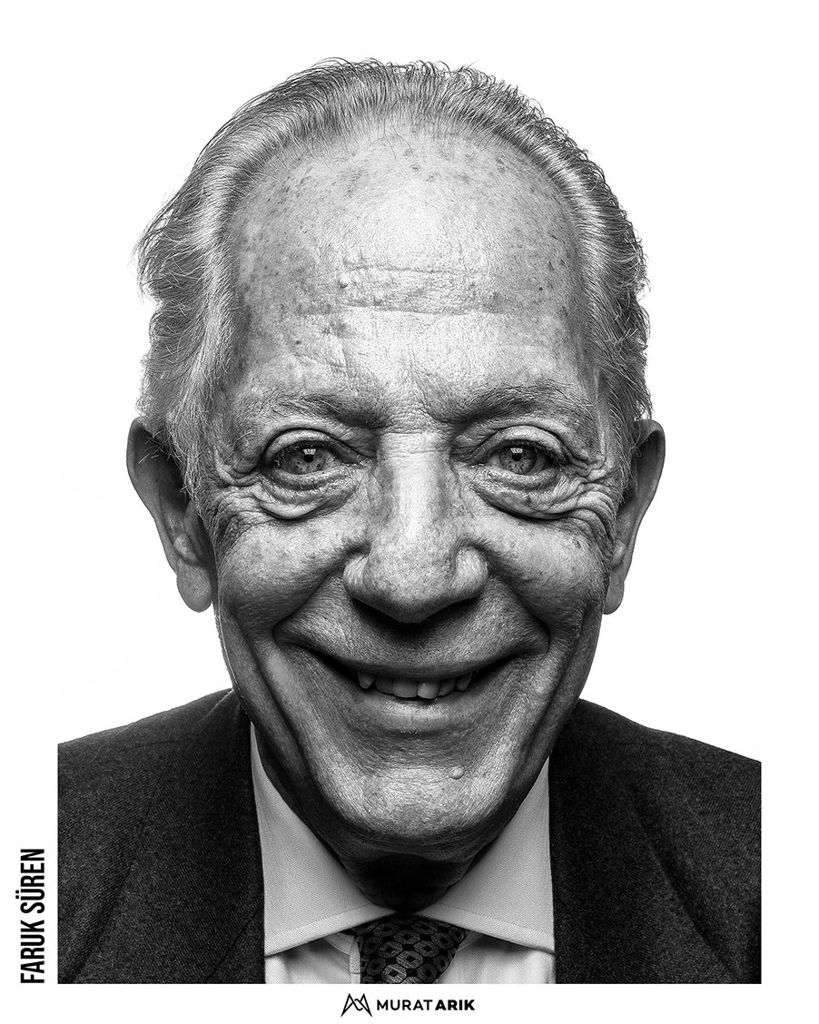 Black-and-white portrait of an elderly man with a big smile, wearing a suit and tie.