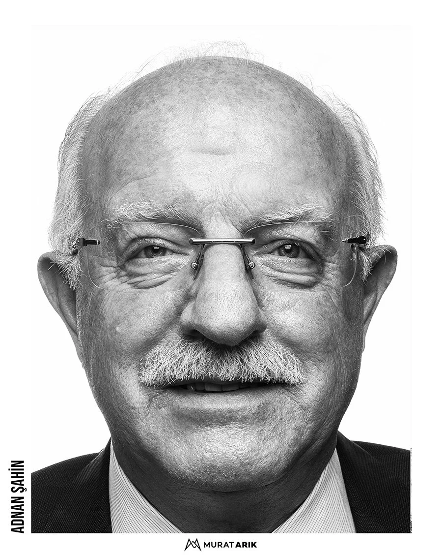Black and white portrait of an older man with glasses, a mustache, and a bald head, wearing a suit and tie.