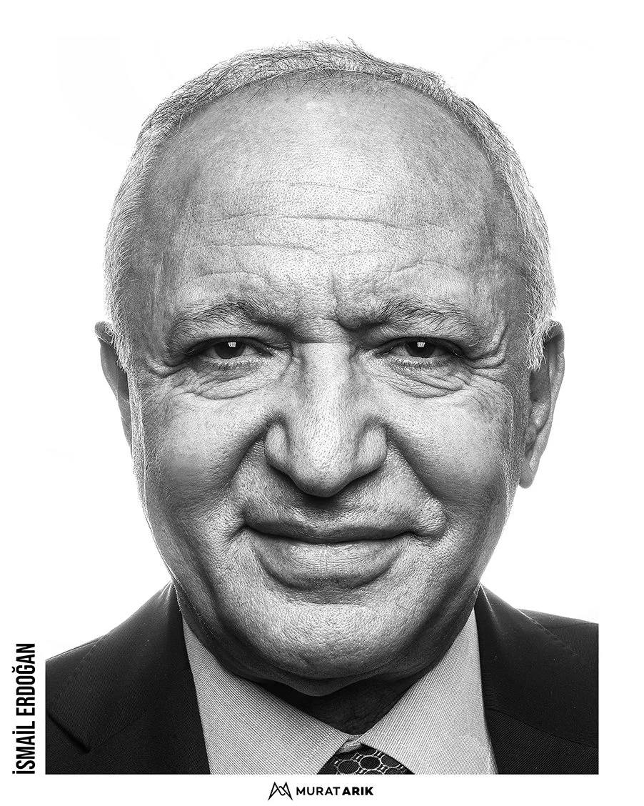 Close-up black and white portrait of a smiling older man wearing a suit and tie.