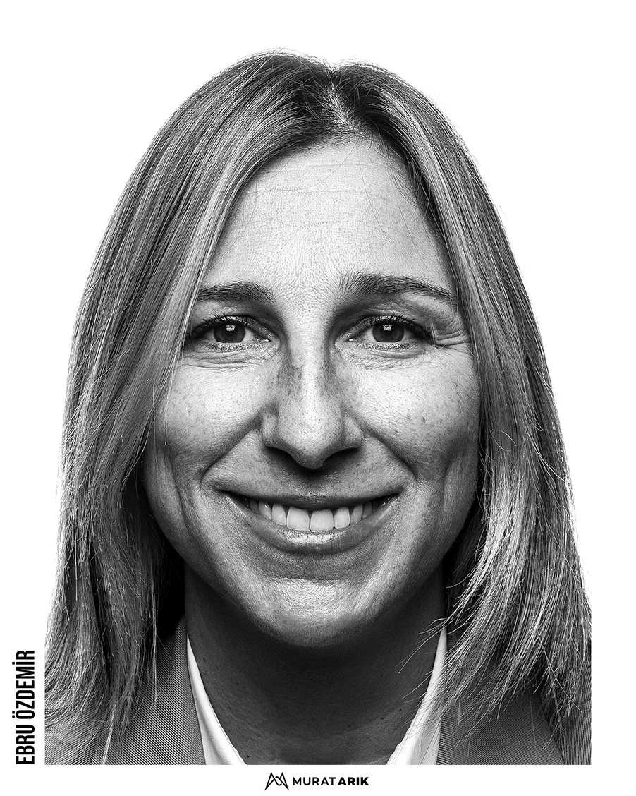 Close-up black and white portrait of a smiling woman with straight hair, wearing a business suit.