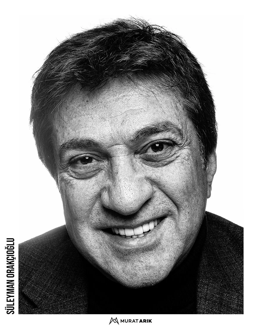 Black and white portrait of a smiling man with dark hair, wearing a dark jacket, with the name 'Süleyman Orakçıoğlu' written vertically on the left and 'Murat Arık' signed at the bottom.