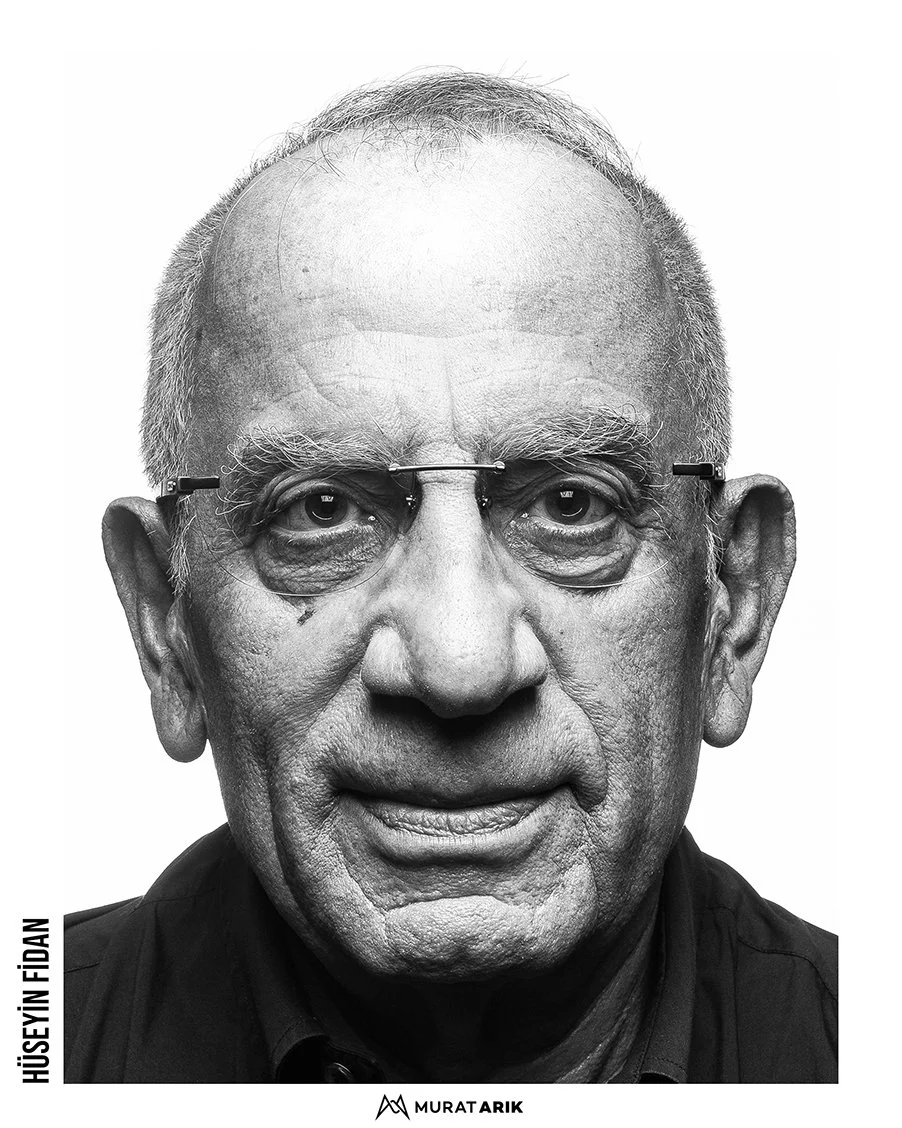 Black and white close-up portrait of an elderly man with glasses, short hair, and prominent facial features.