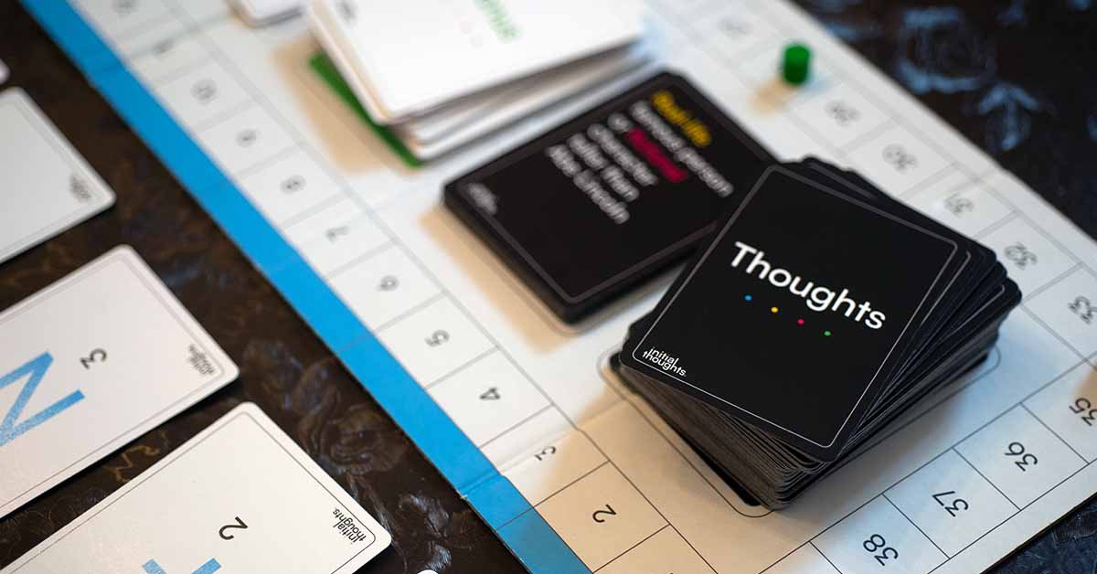 Cards and game pieces on a table for a game called 'Thoughts'.