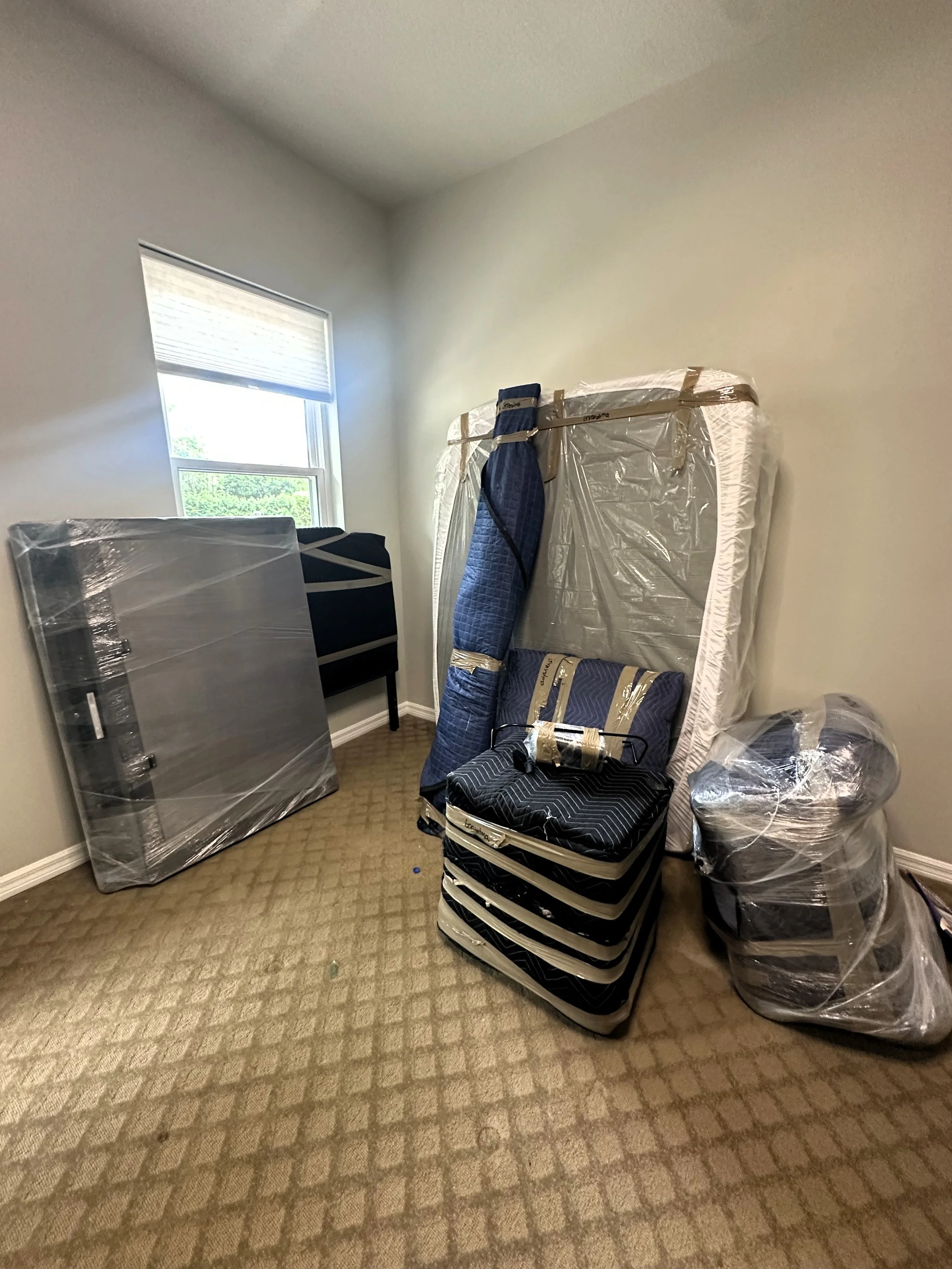 Furniture and mattresses professionally wrapped in protective moving blankets and plastic wrap by Easy Peasy Moving, LLC.