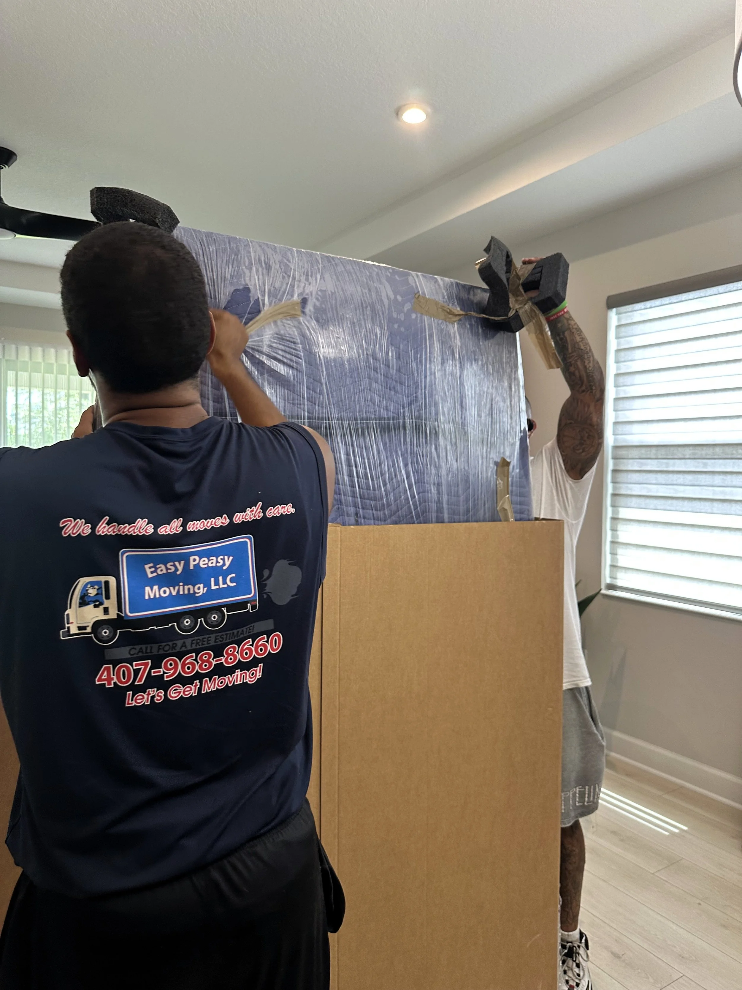 Easy Peasy Moving, LLC movers carefully handling large furniture protected with moving blankets during a residential move.  Copy