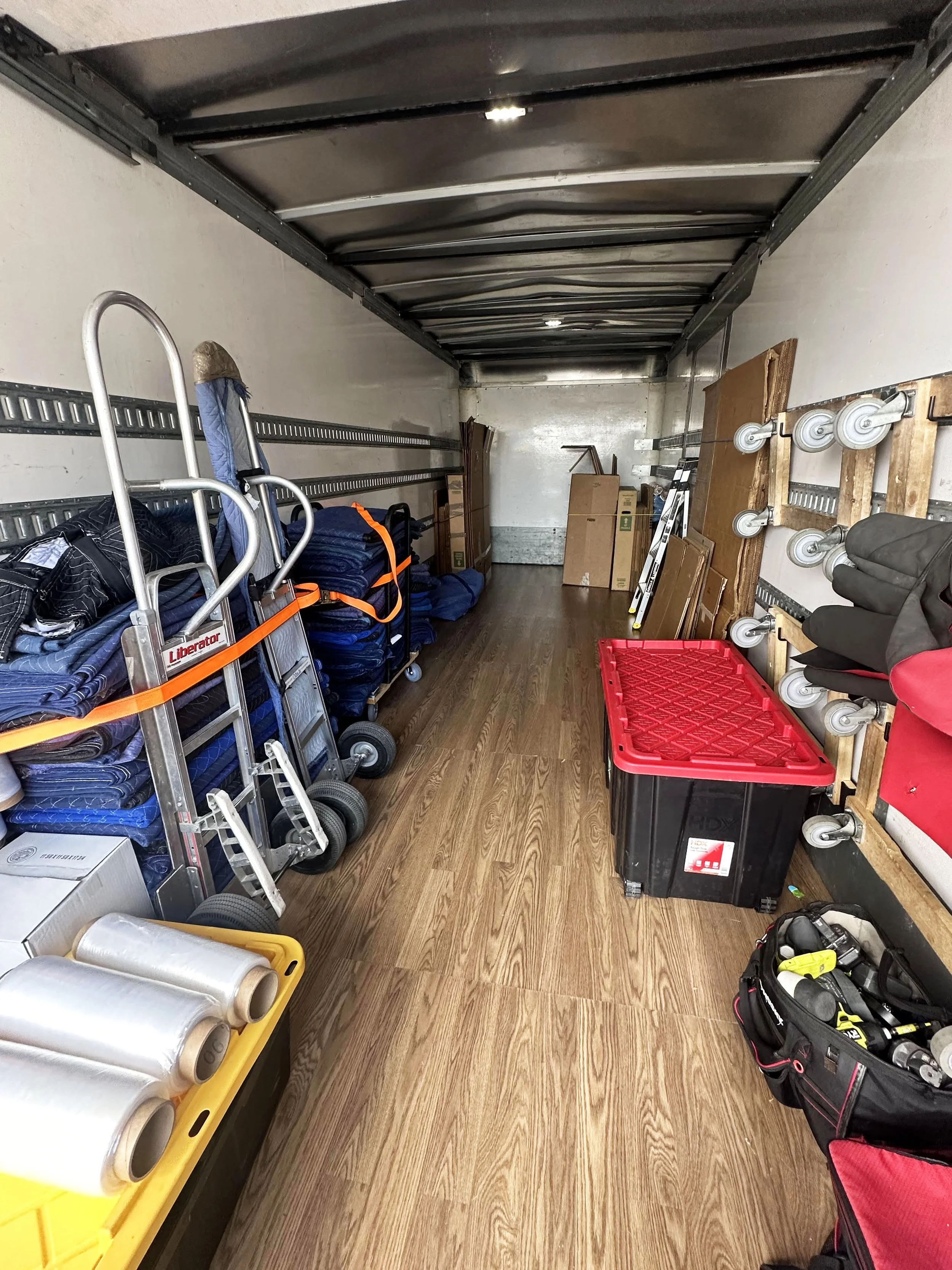 Inside of a moving truck with neatly organized moving blankets, dollies, straps, and equipment used by Easy Peasy Moving, LLC in Central Florida