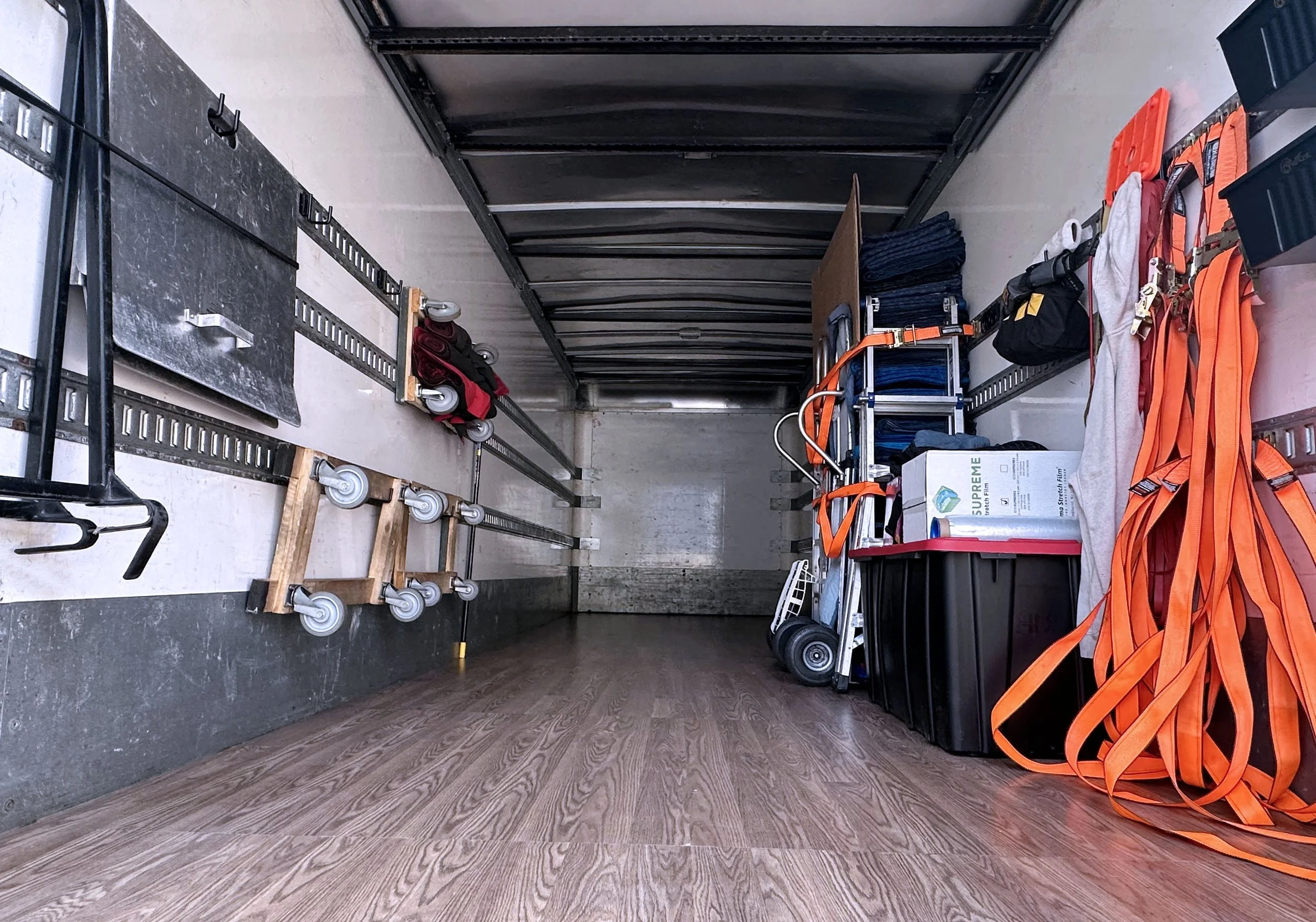 Inside an Easy Peasy Moving, LLC moving truck with various tools, equipment, and supplies stored on shelves and the floor, including dollies, straps, and boxes in Altamonte Springs, FL and surrounding areas.