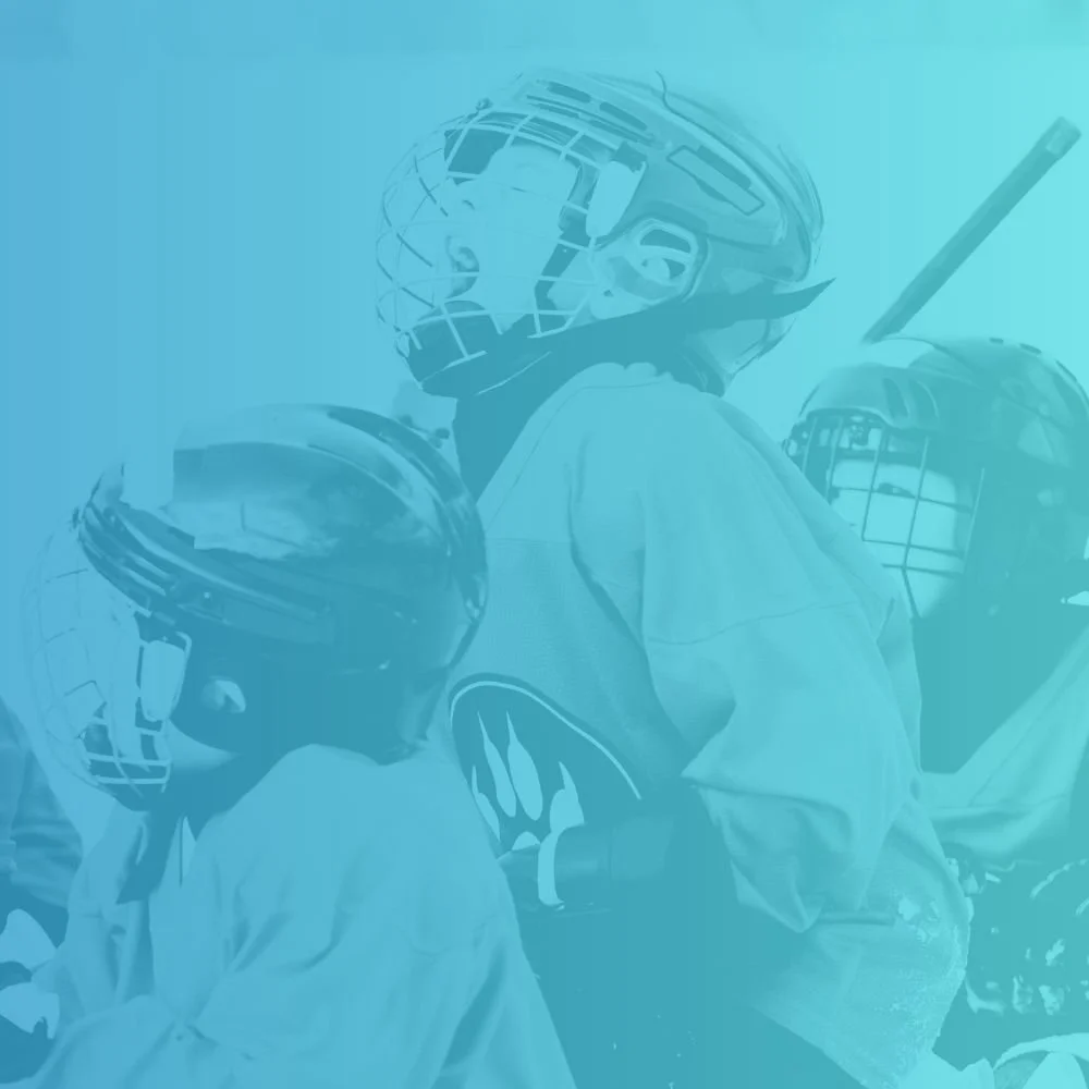 Ice hockey players wearing helmets and hockey gear, gathered on the ice during a game or practice.