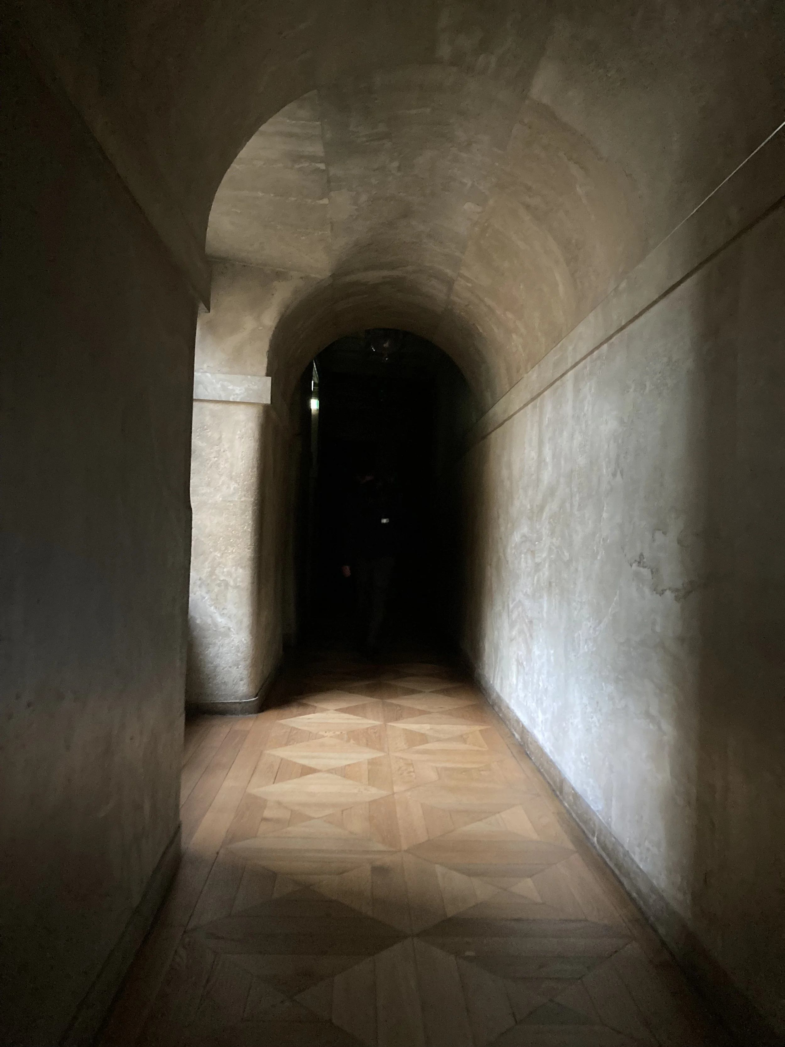 Long couloir en enfilade au château de Fontainebleau, portes successives s'ouvrant vers la lumière