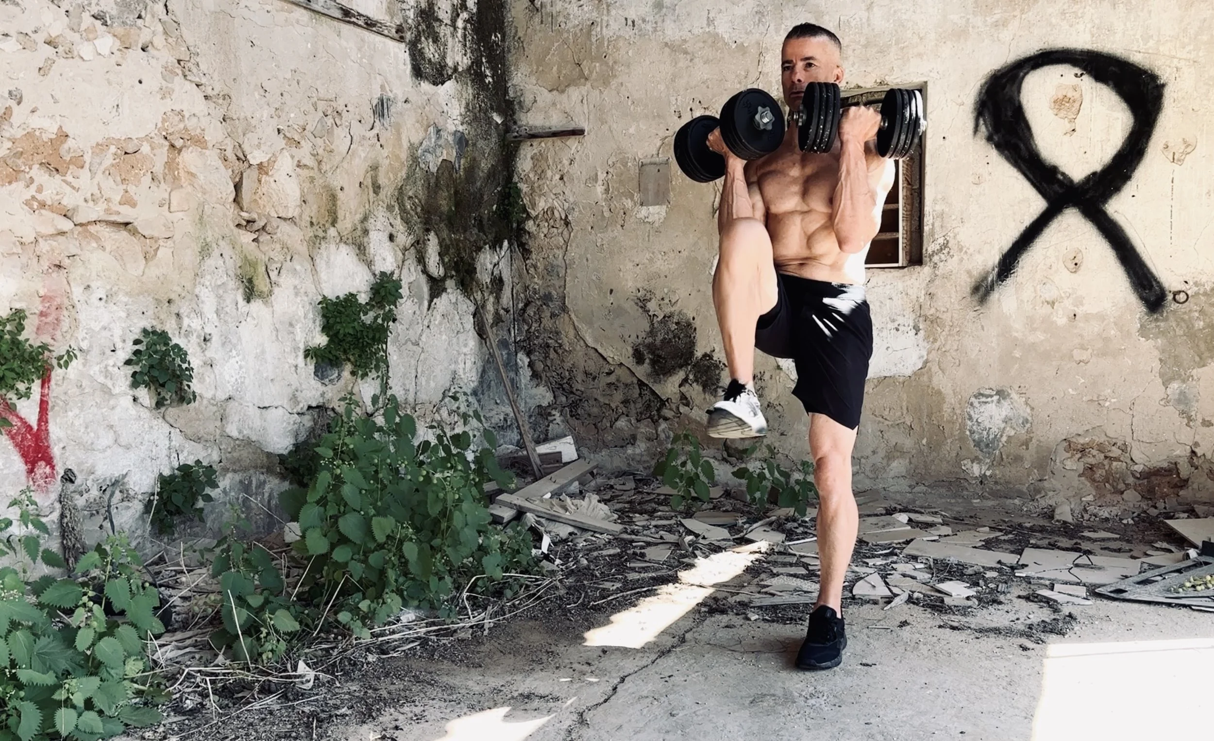 man doing a front rack march with two dumbbells