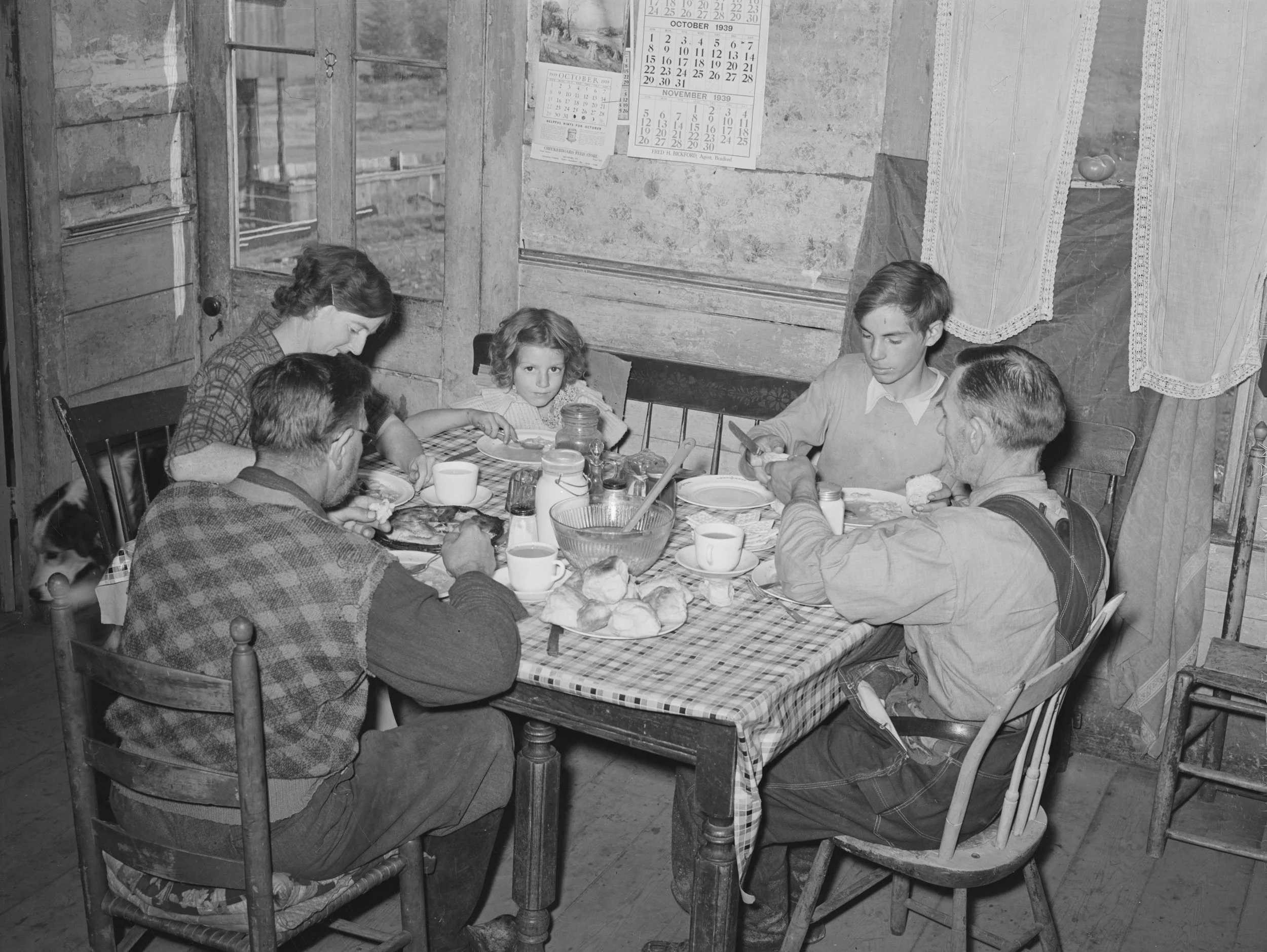 black and white historical photo of a family eating at the table