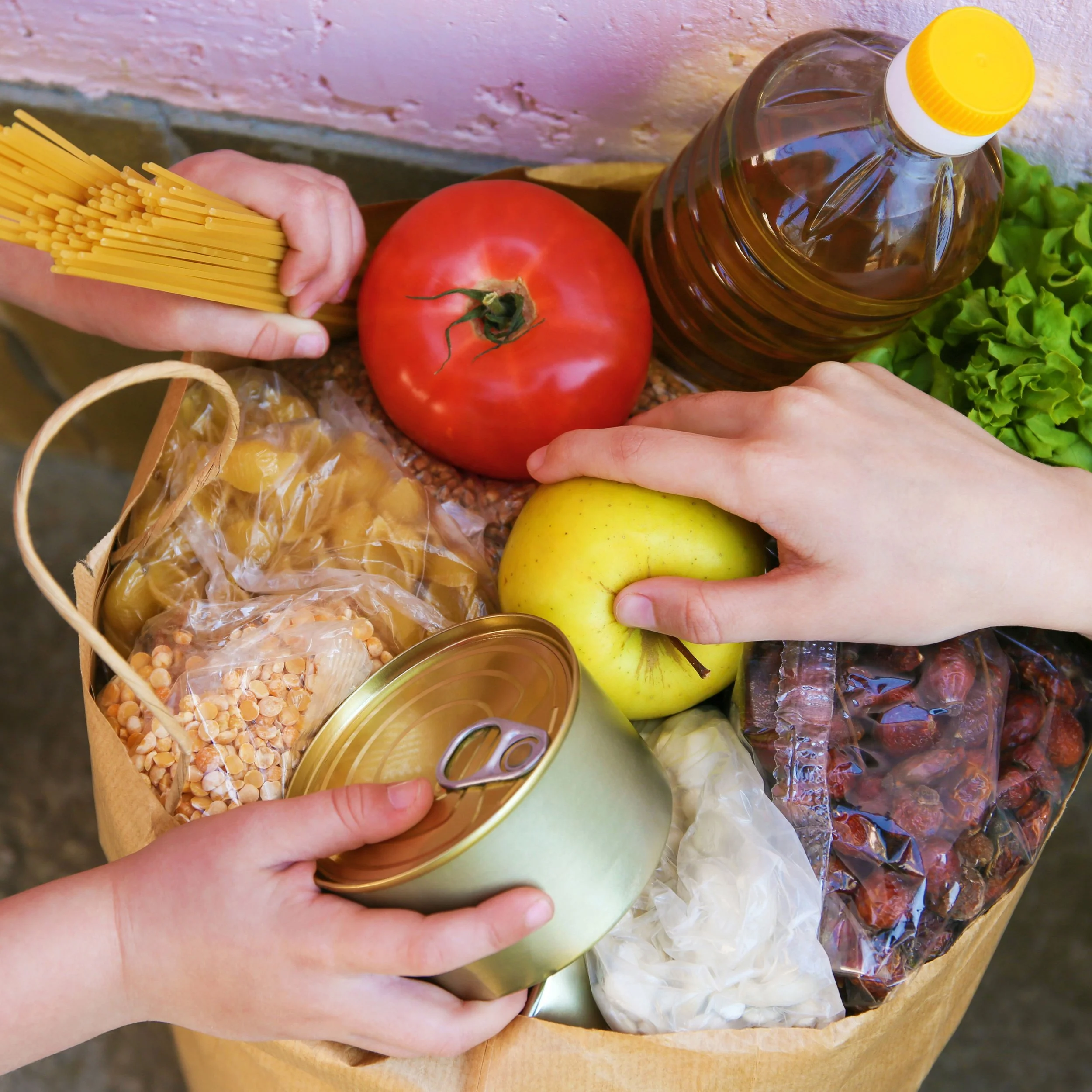 Kid and adult hands donating to a foodbank