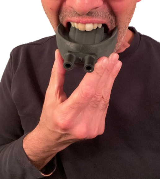 Close-up of a man holding a black thermal imaging or night vision device near his mouth, with part of his face visible.