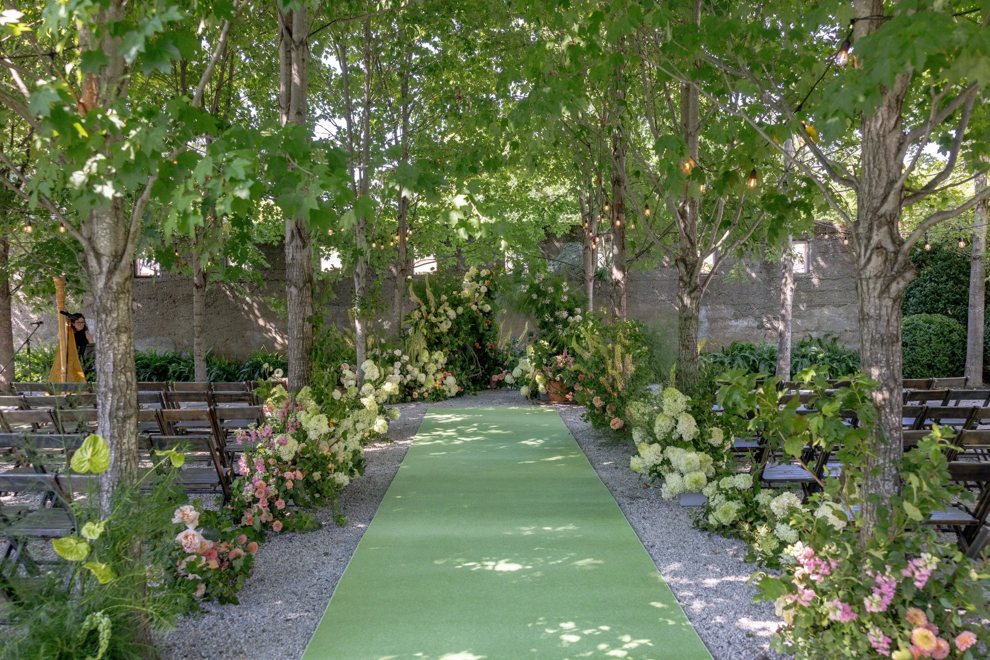 A green aisle runner lined with lush floral arrangements guides the way to the altar at Valley Rock Inn in Sloatsburg, photographed by Jenny Fu.
