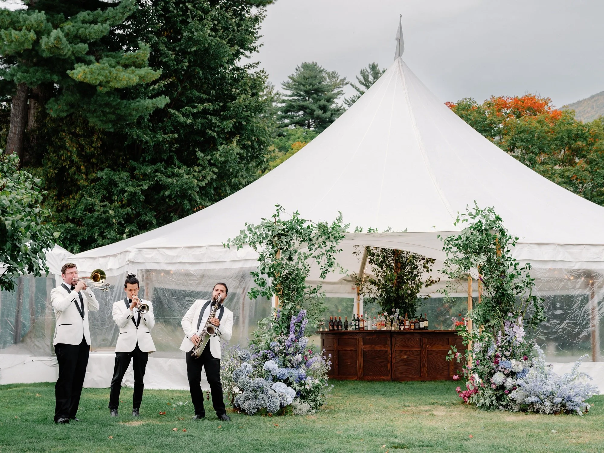 Live band playing jazz music outside the reception tent during wedding celebration at Ausable Club