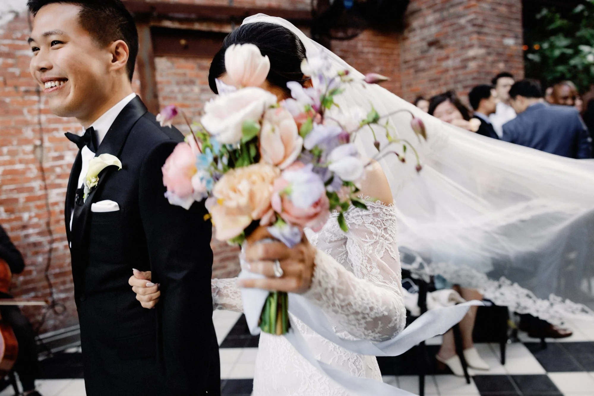 Bride and groom recessional with bouquet and veil flowing at The Wythe Hotel wedding in Brooklyn