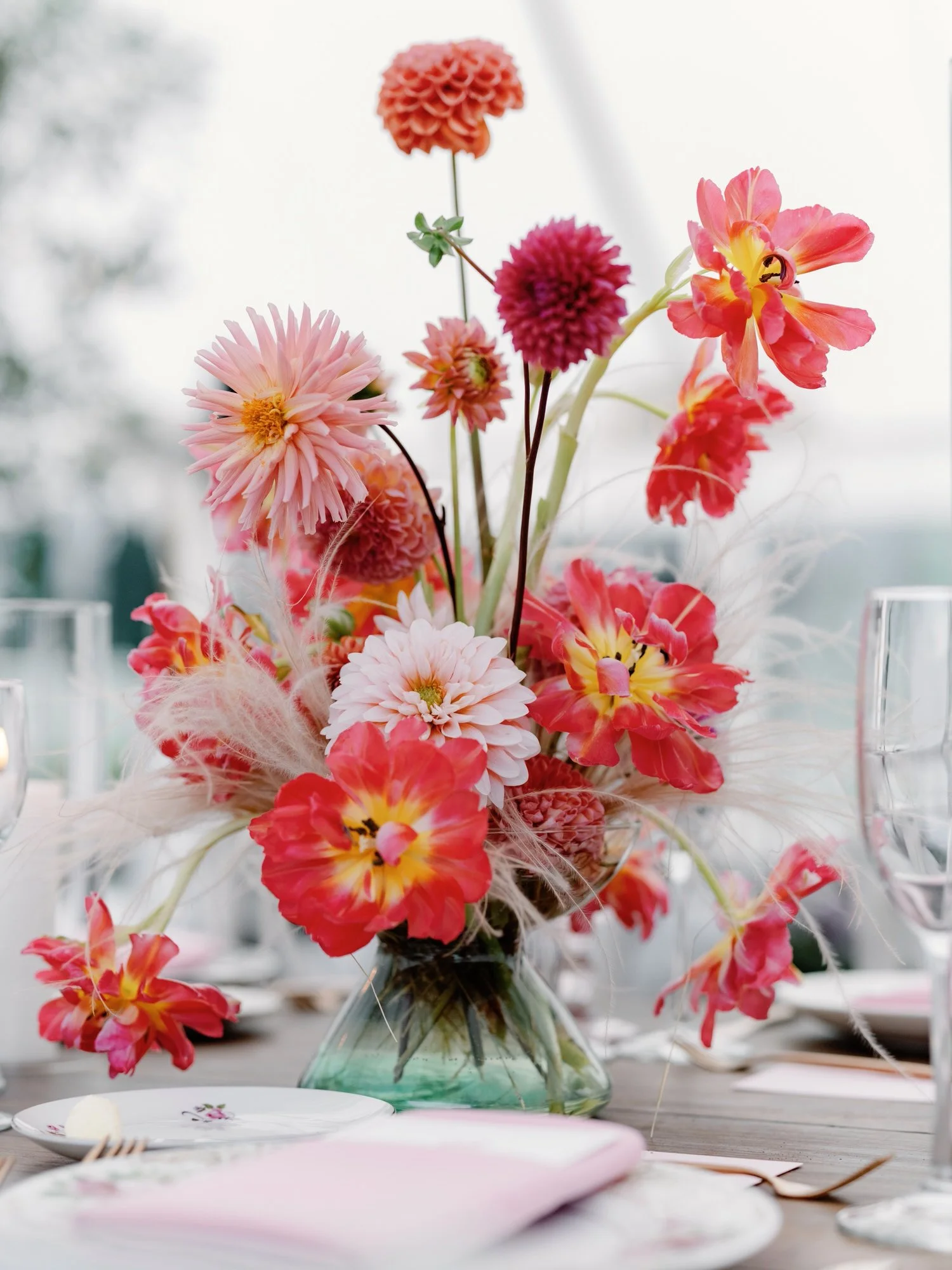 Vibrant pink and coral floral centerpiece on wedding reception table at The Ausable Club in the Adirondacks