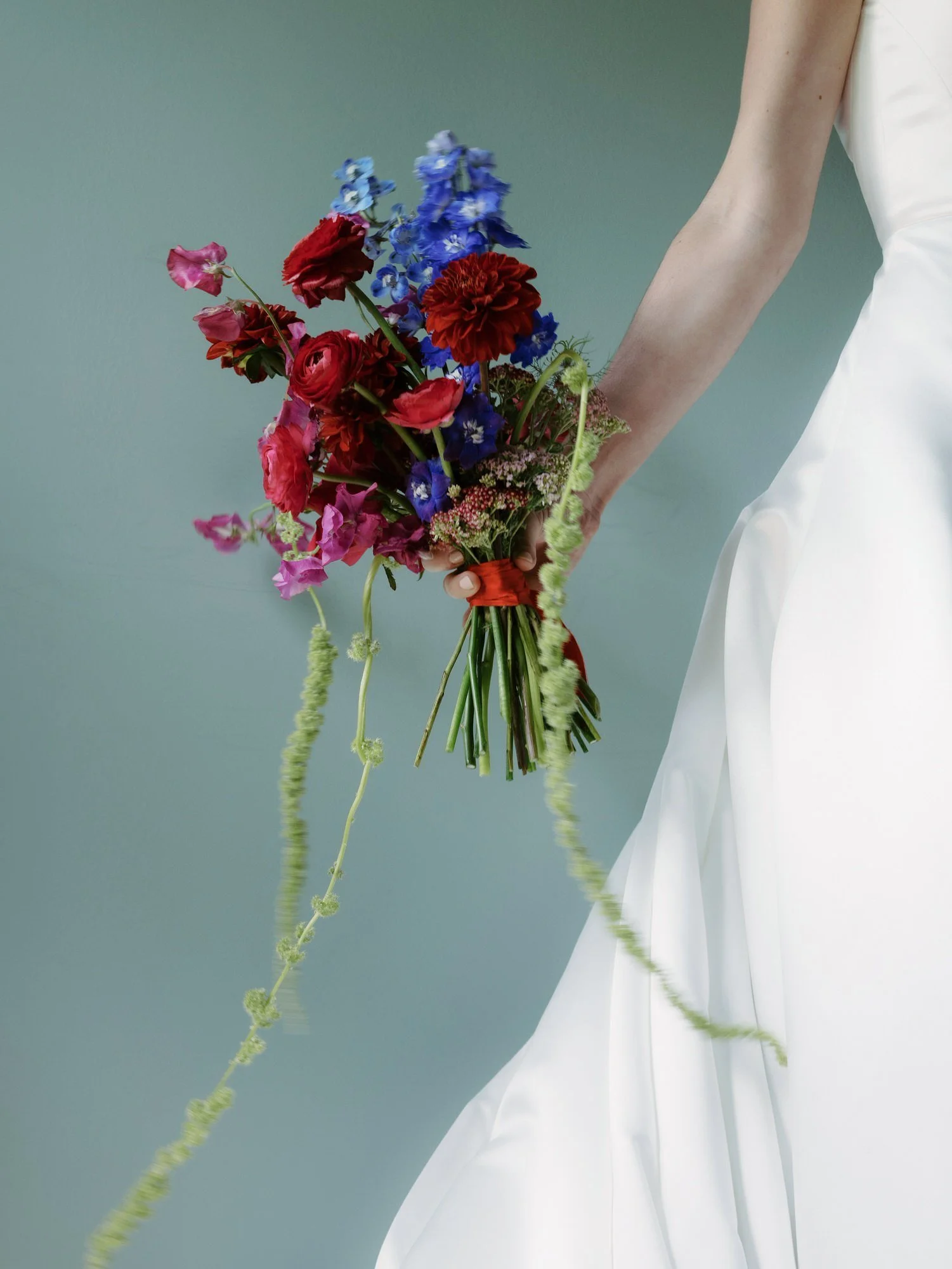aa-0355-bride-holding-red-and-blue-floral-bouquet-troutbeck-amenia-ny-planned-by-ashley-douglass-jenny-fu.jpg