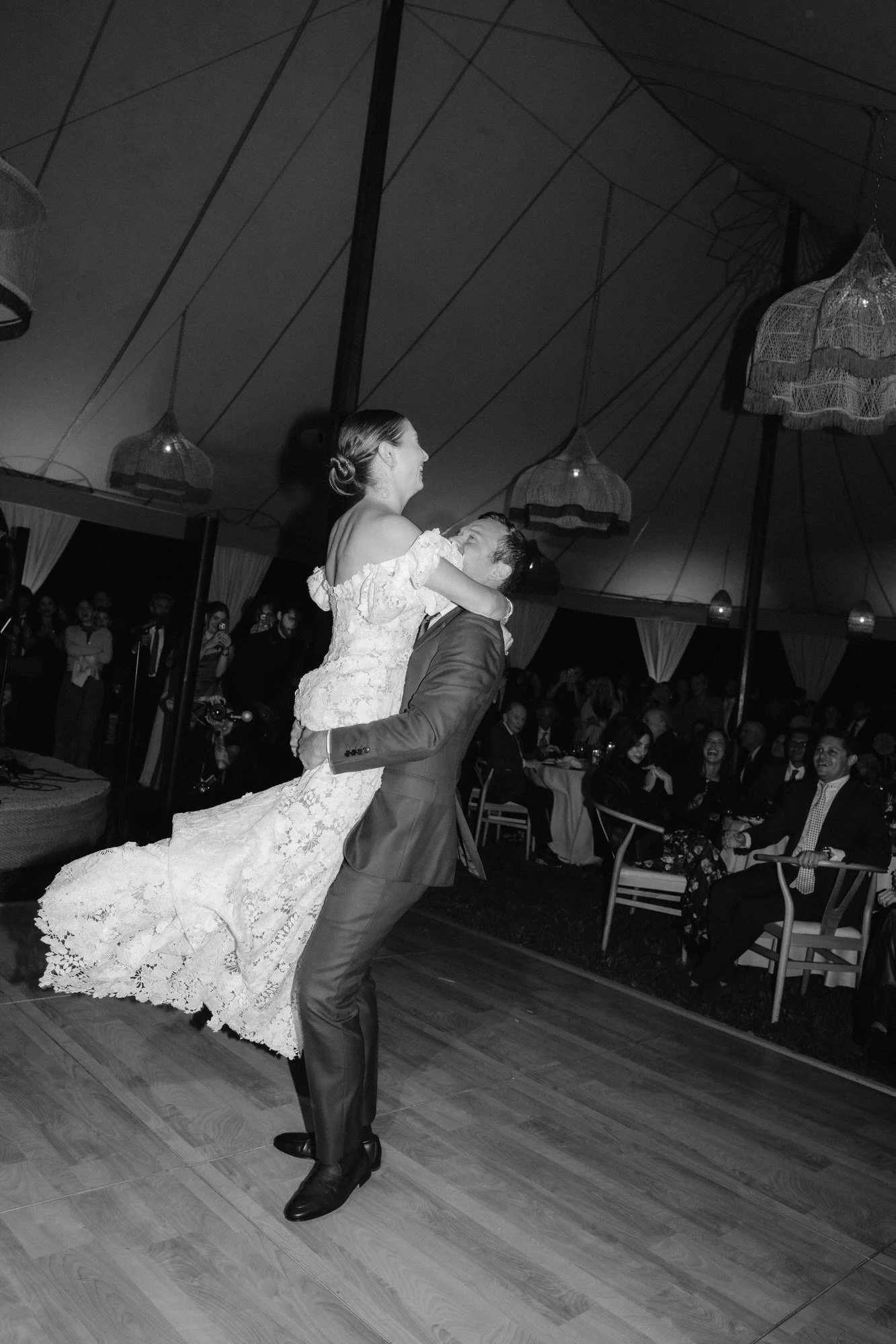 Bride and groom sharing their first dance beneath the tent surrounded by guests at Troutbeck in Amenia, photographed by Jenny Fu.