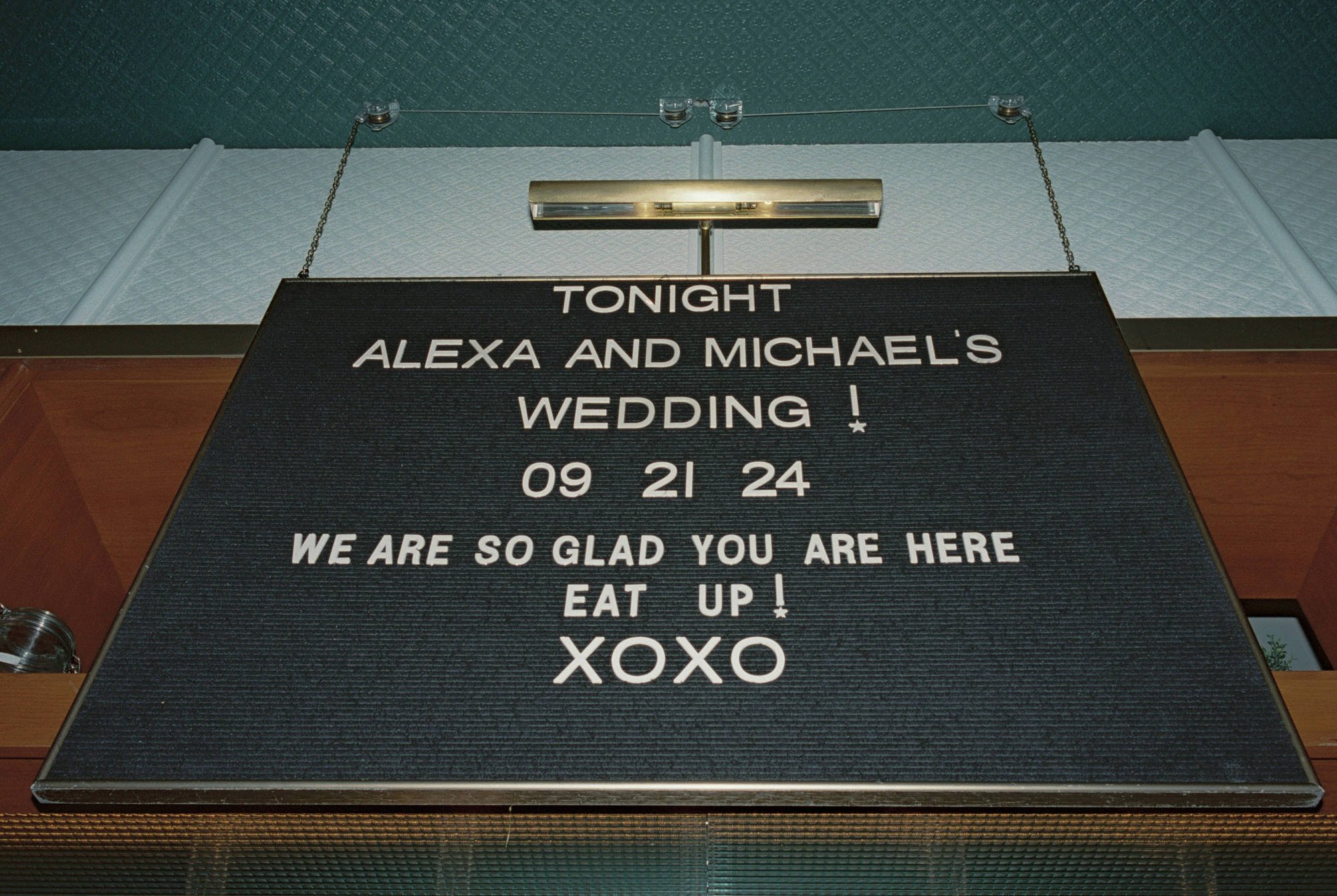Black sign reading “Tonight Alexa and Michael’s Wedding” hanging in the restaurant at Torrisi in Manhattan, photographed by Jenny Fu.
