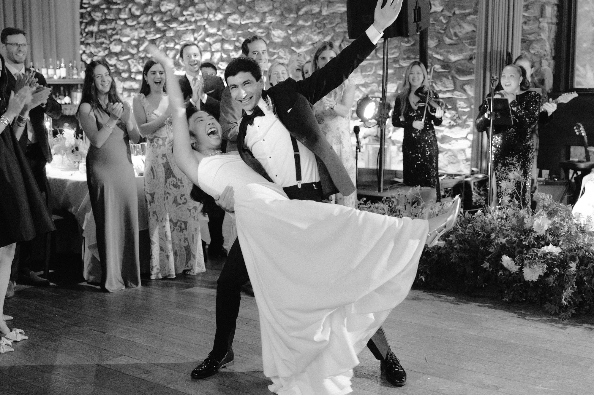 First dance dip in black and white as guests cheer around the couple at Blue Hill at Stone Barns, photographed by Jenny Fu.