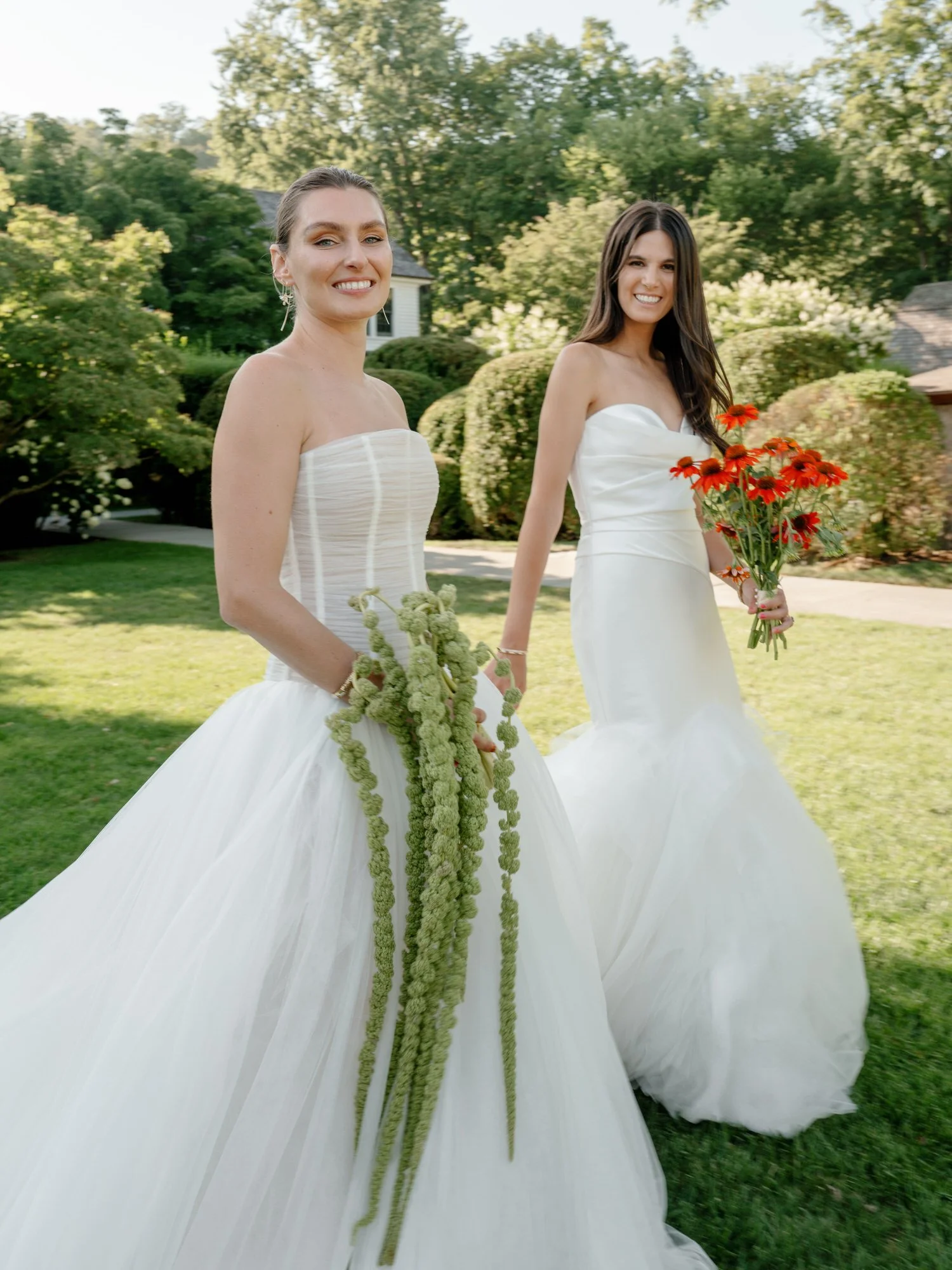 Brides walking across the lawn holding bouquets at Valley Rock Inn in Sloatsburg, photographed by Jenny Fu.
