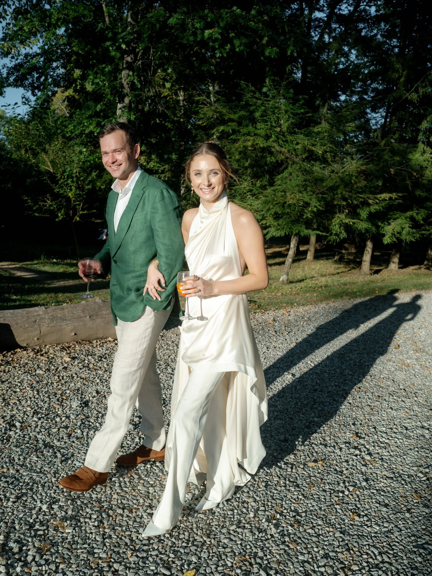 Bride and groom walking hand in hand during golden hour outside at Troutbeck in Amenia, photographed by Jenny Fu.