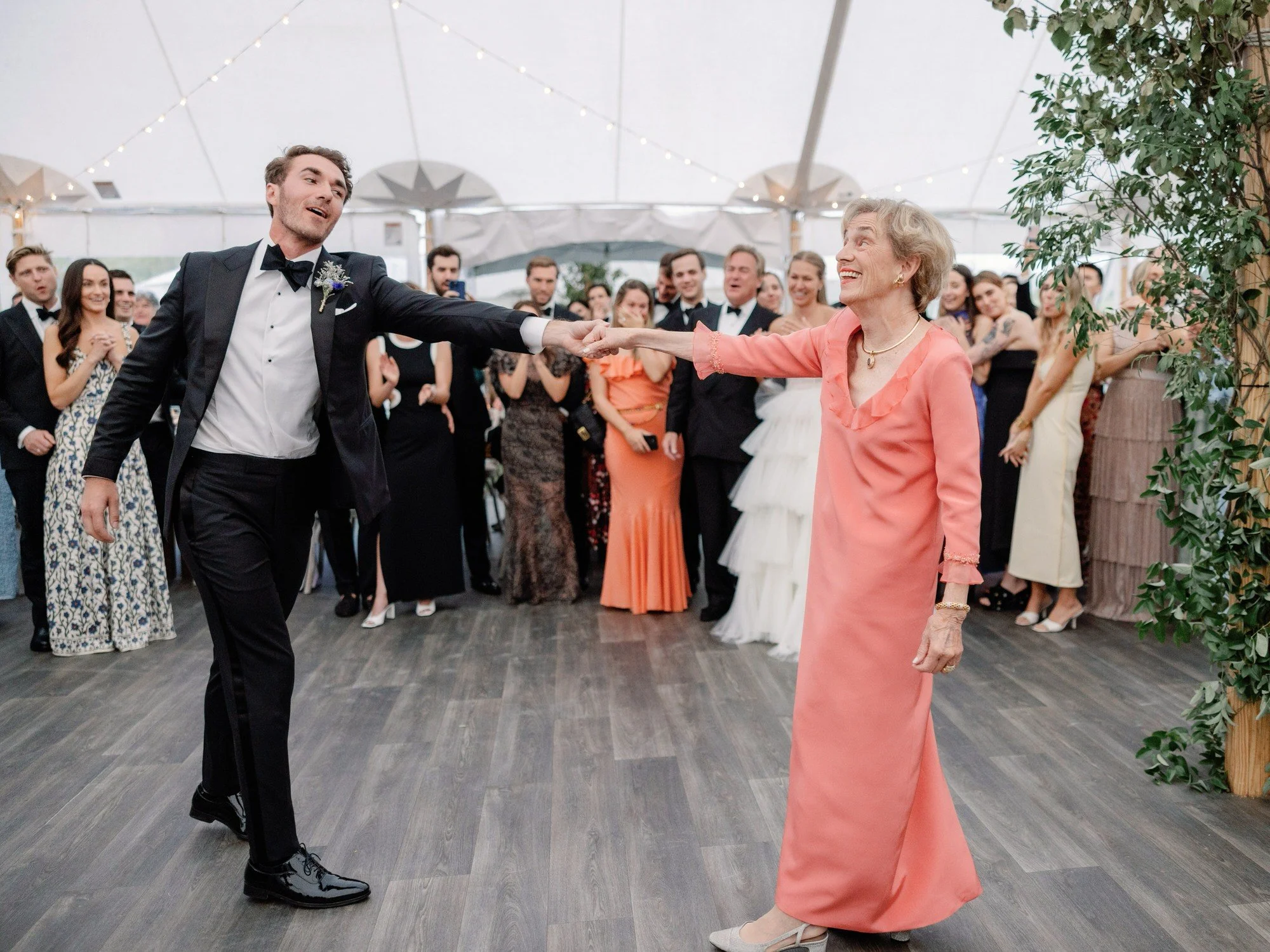 Groom dancing joyfully with his grandmother during the wedding reception at Ausable Club