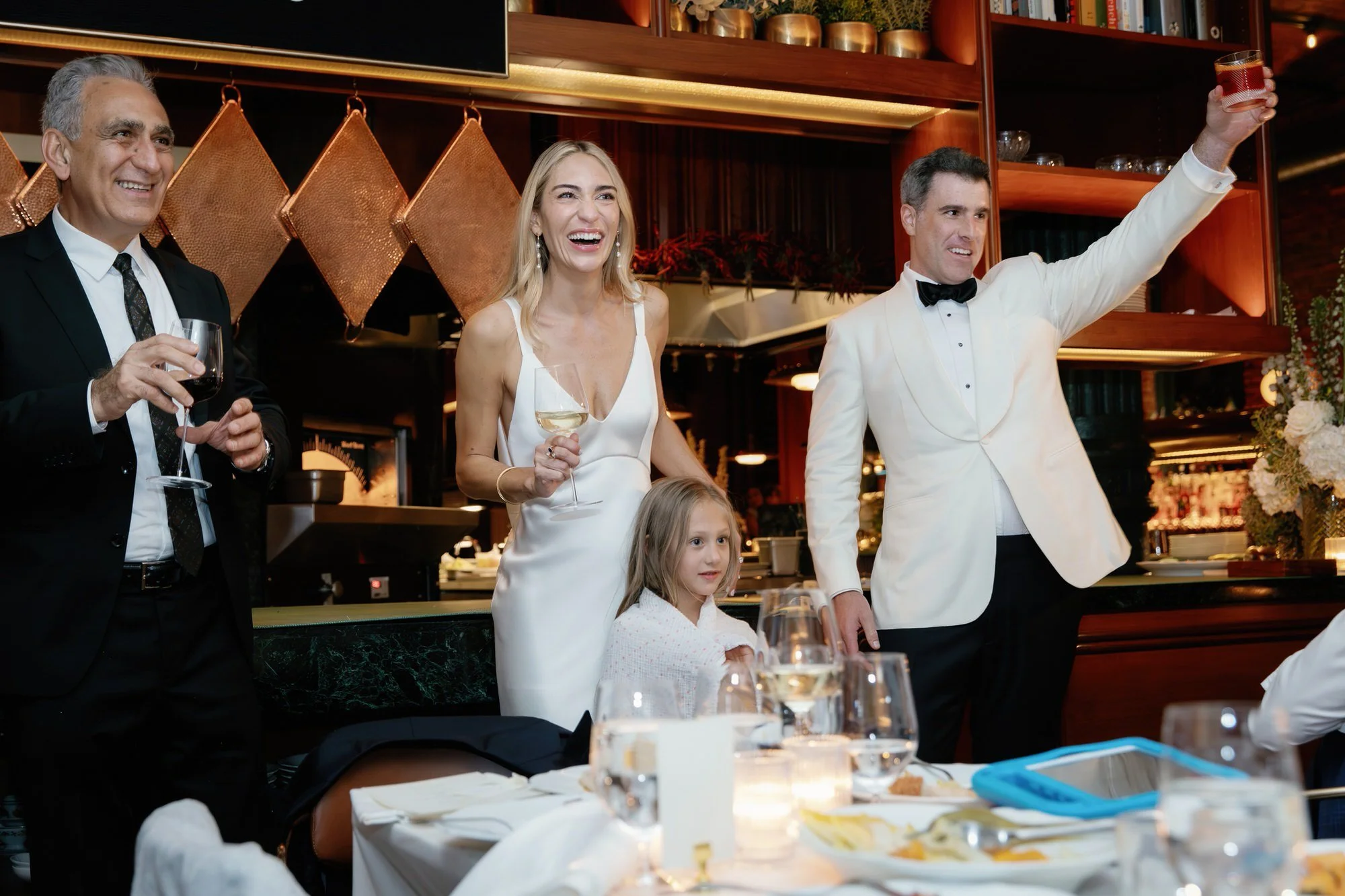 Bride and groom raising a toast with family and friends during their dinner reception at Torrisi in Manhattan, photographed by Jenny Fu.