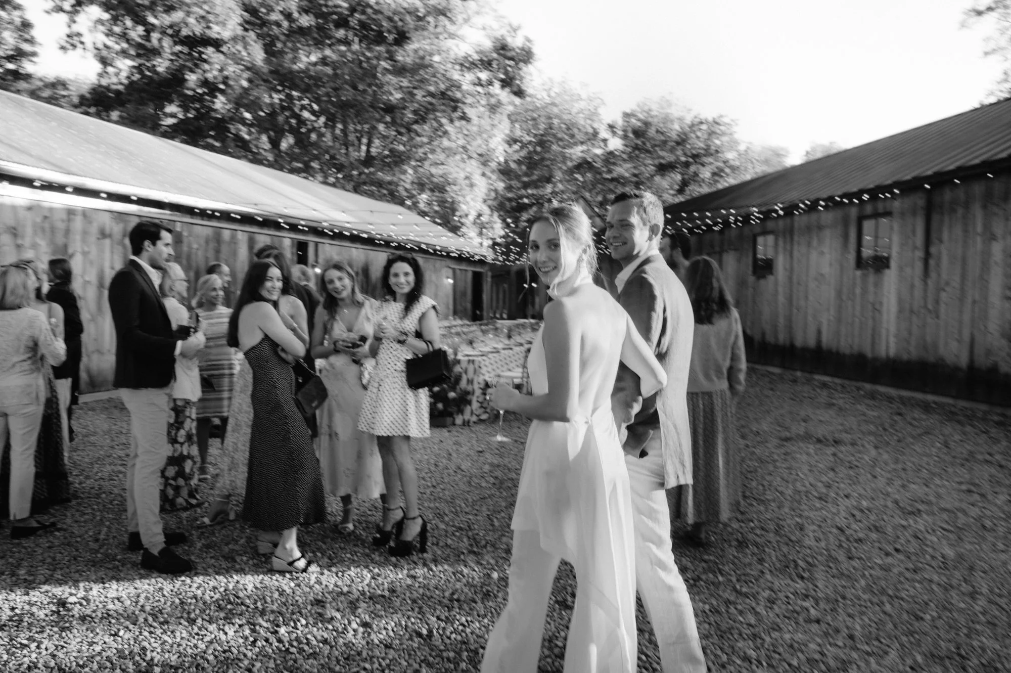 Guests mingling during the welcome party in the gravel courtyard at Troutbeck in Amenia, photographed by Jenny Fu.