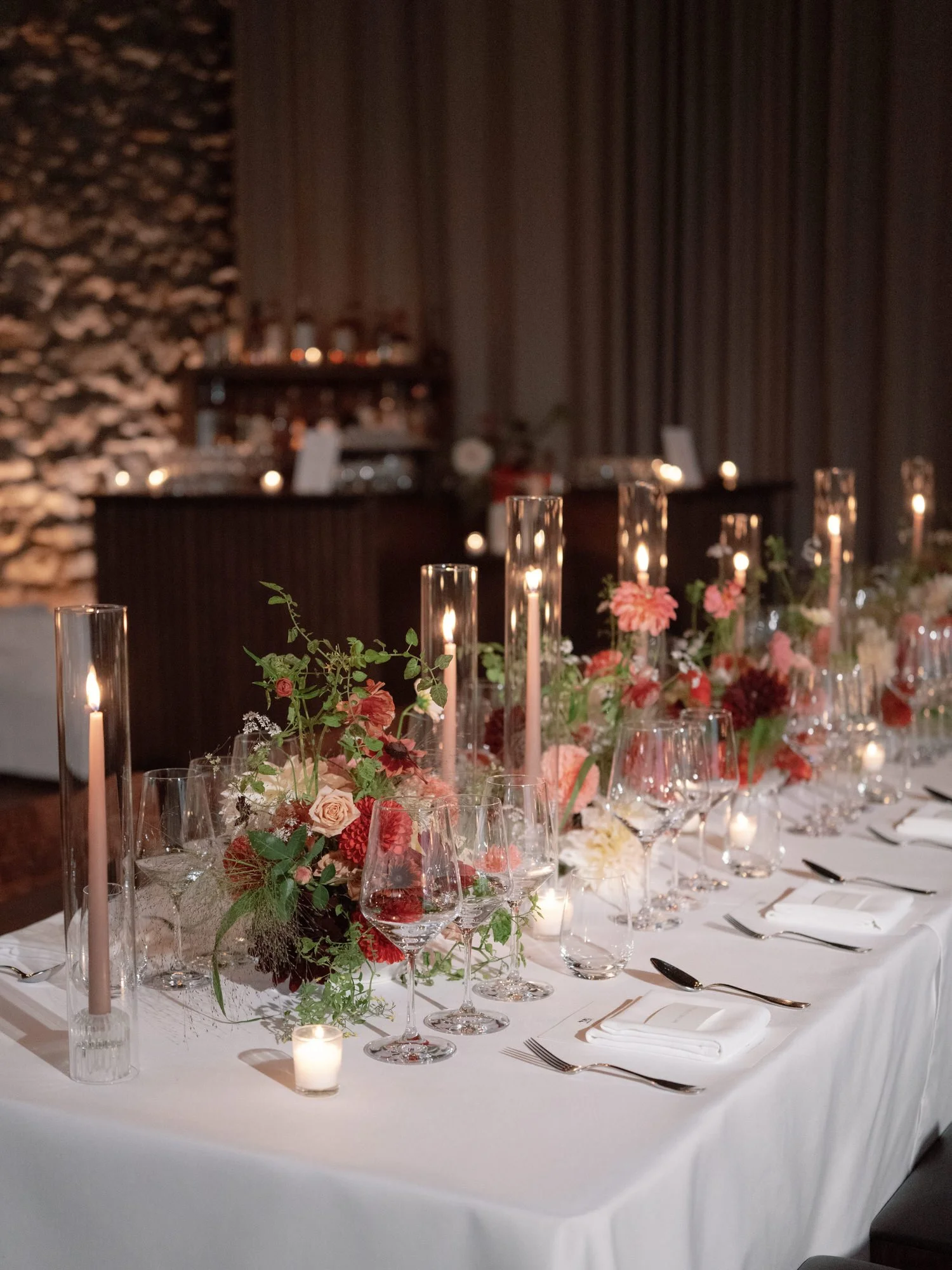 Close reception table detail with taper candles, glassware, and lush centerpieces at Blue Hill at Stone Barns, photographed by Jenny Fu.