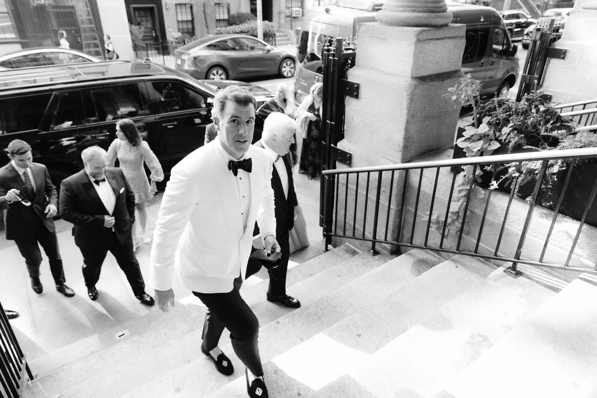 Groom walking up the church steps with family and guests arriving for the ceremony at St. Francis Xavier Church in Chelsea, photographed by Jenny Fu.
