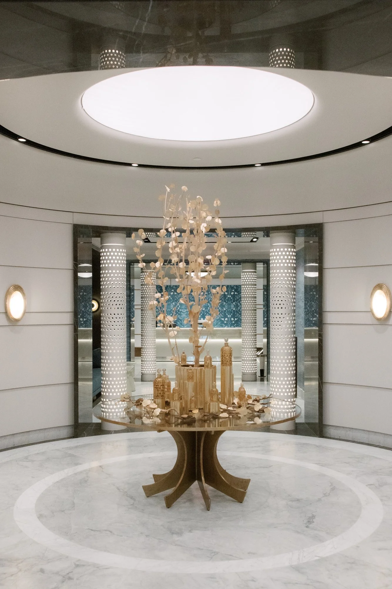 Gilded sculpture on a marble table beneath a circular skylight at the Waldorf Astoria New York, photographed by Jenny Fu.