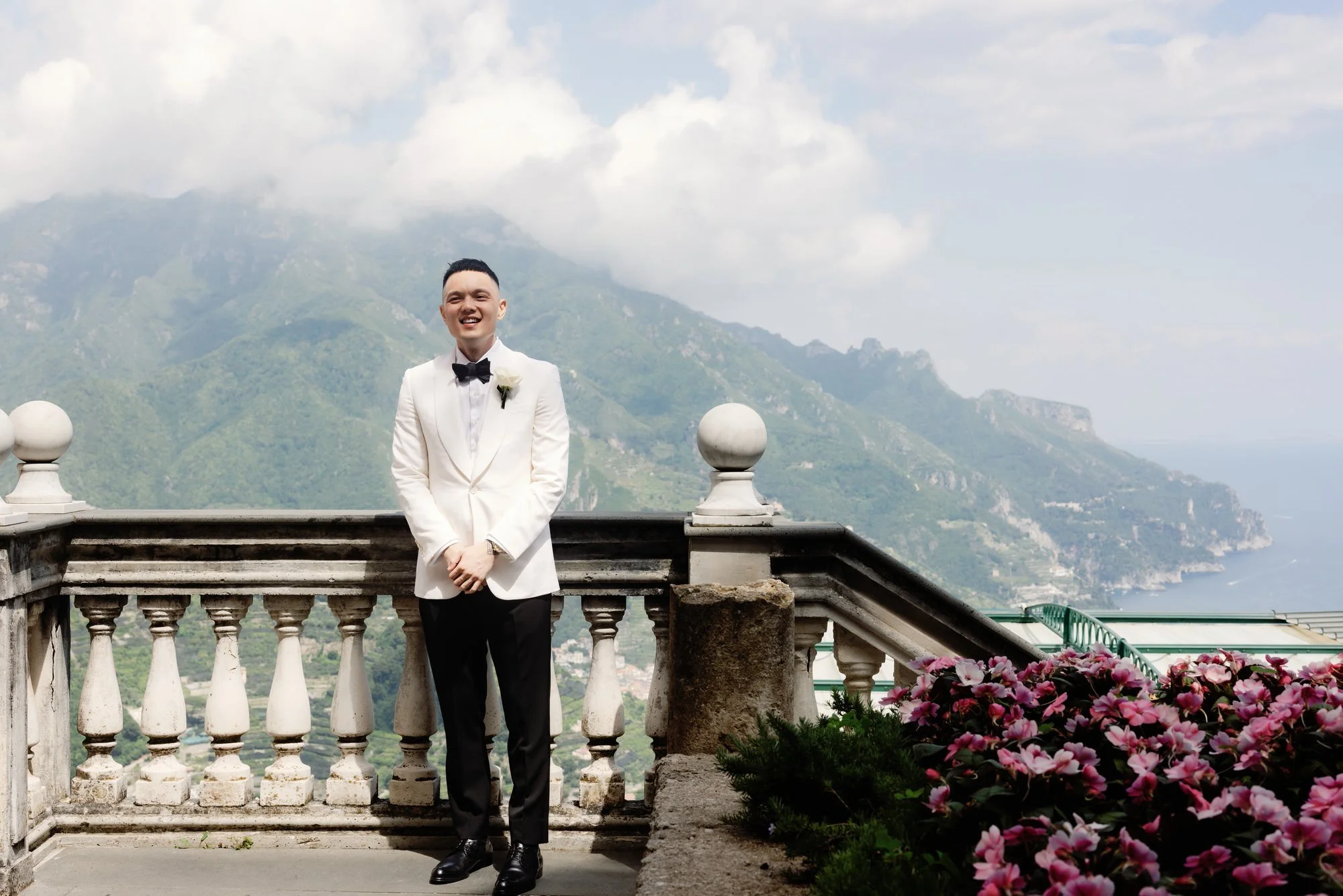 Groom standing on the terrace overlooking the Amalfi Coast mountains at Caruso, A Belmond Hotel in Ravello, Italy, photographed by Jenny Fu.
