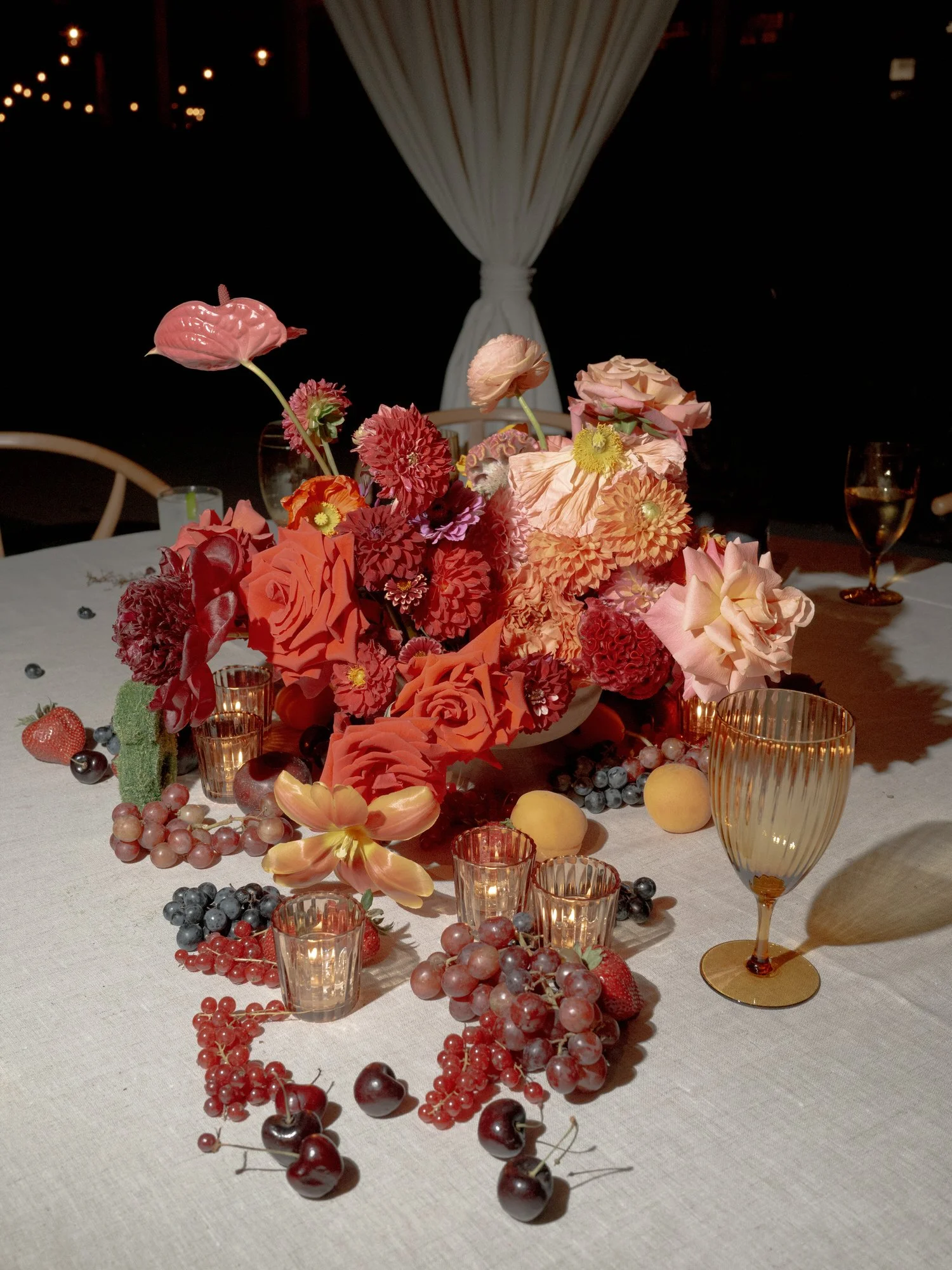 Colorful floral arrangement surrounded by candles, grapes, and cherries on the dinner table at Valley Rock Inn in Sloatsburg, photographed by Jenny Fu.