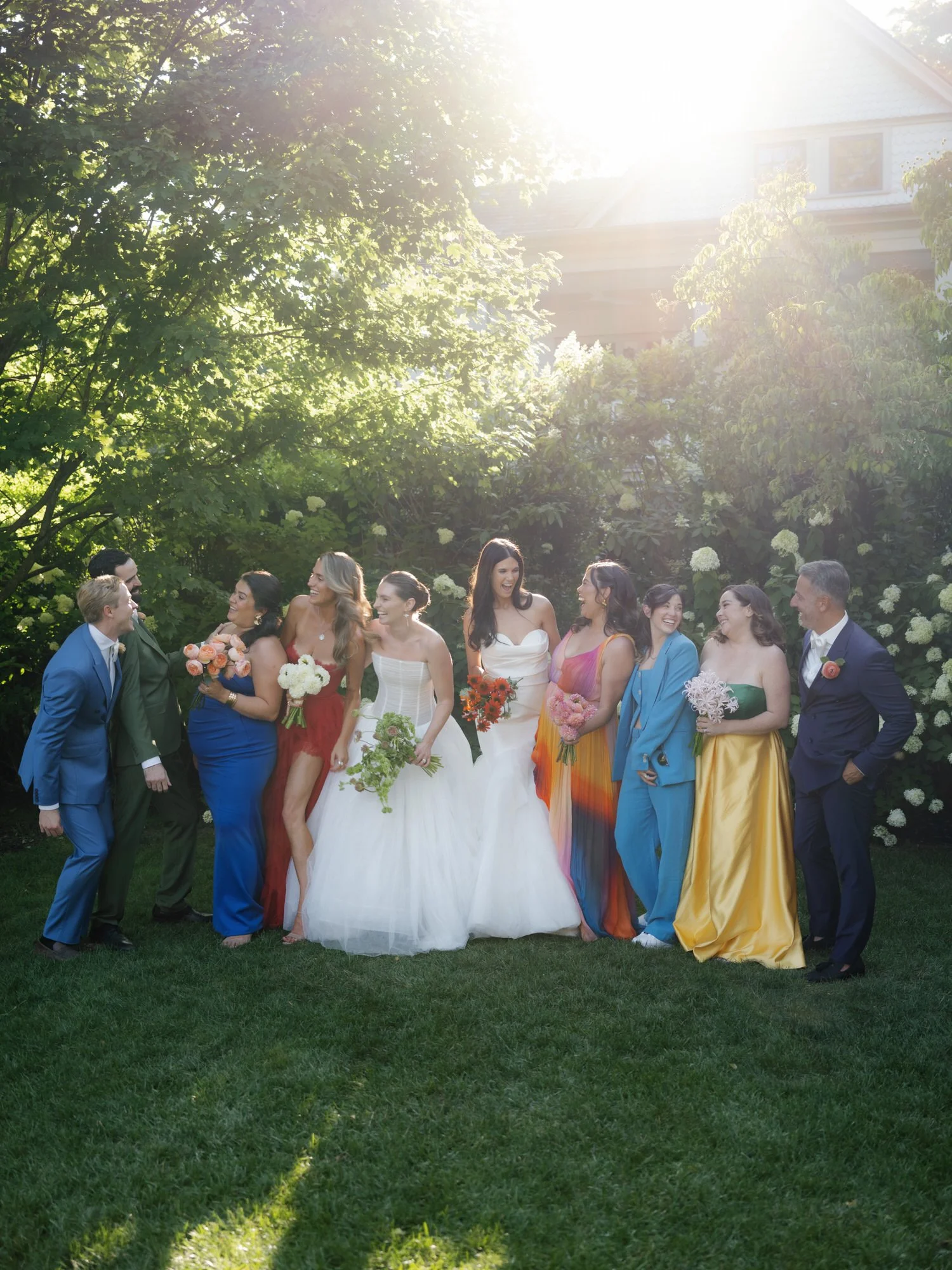Bridal party laughing together in the afternoon garden light surrounded by greenery at Valley Rock Inn in Sloatsburg, photographed by Jenny Fu.