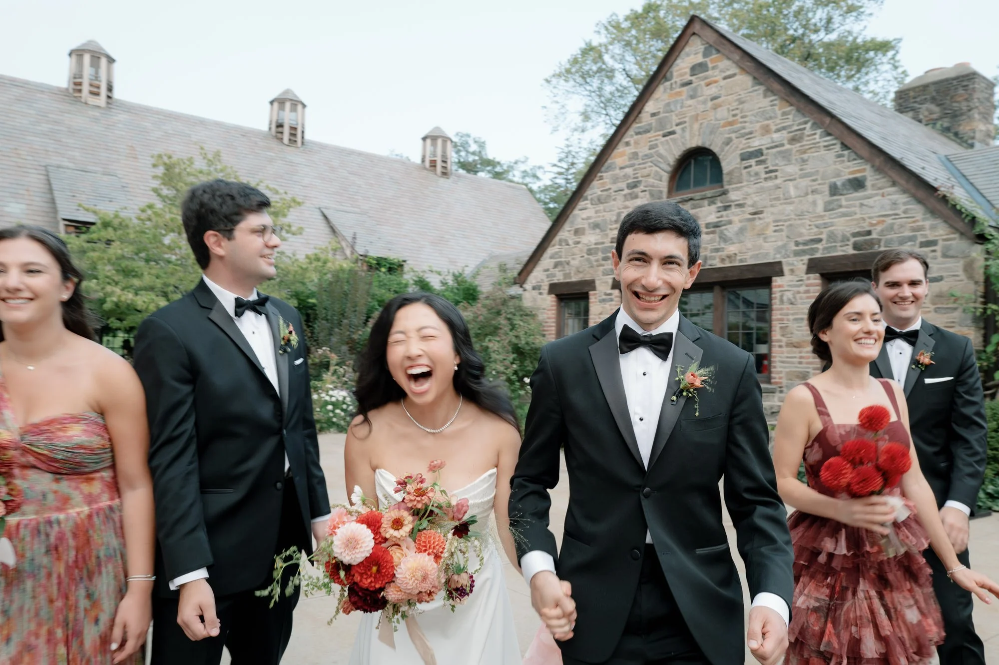 A candid of the wedding party walking and laughing through the courtyard at Blue Hill at Stone Barns, photographed by Jenny Fu.