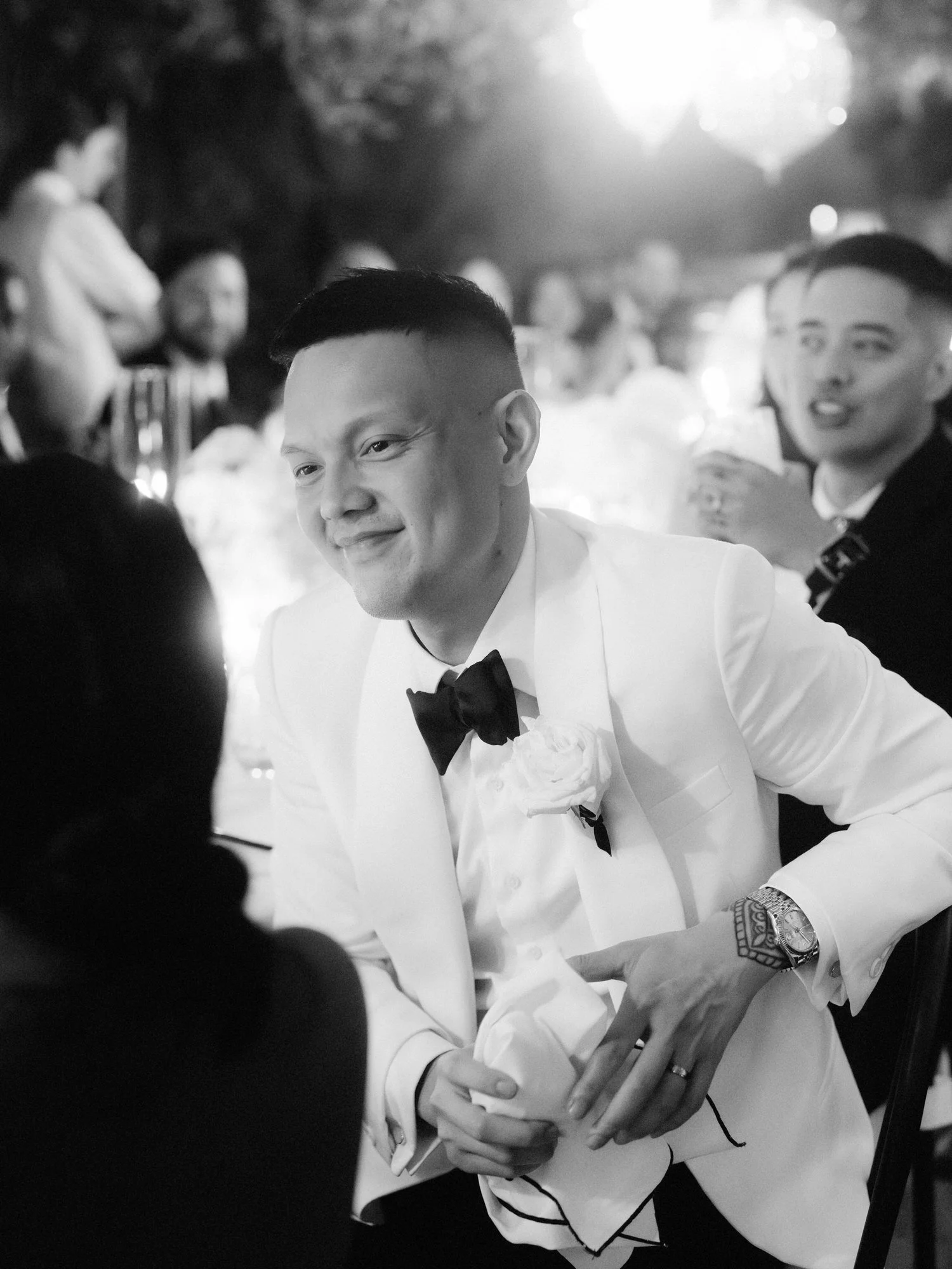 Groom smiling warmly during a dinner toast beneath twinkling lights at Caruso, A Belmond Hotel in Ravello, Italy, photographed by Jenny Fu.
