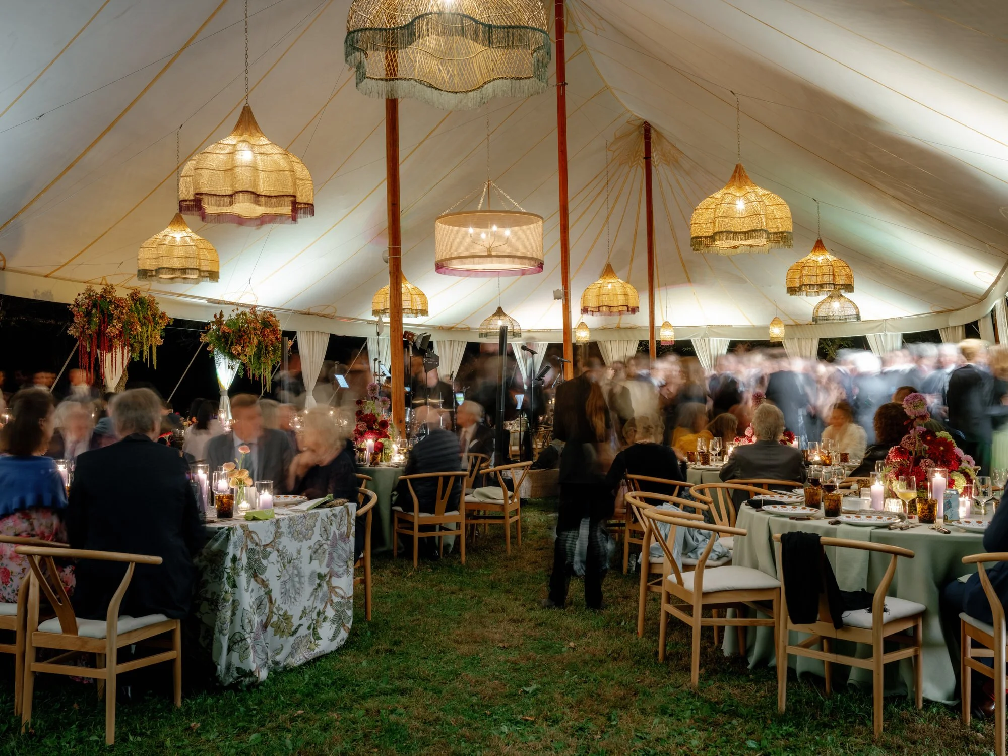 Guests dining and mingling beneath glowing lanterns in the sailcloth tent at Troutbeck in Amenia, photographed by Jenny Fu.