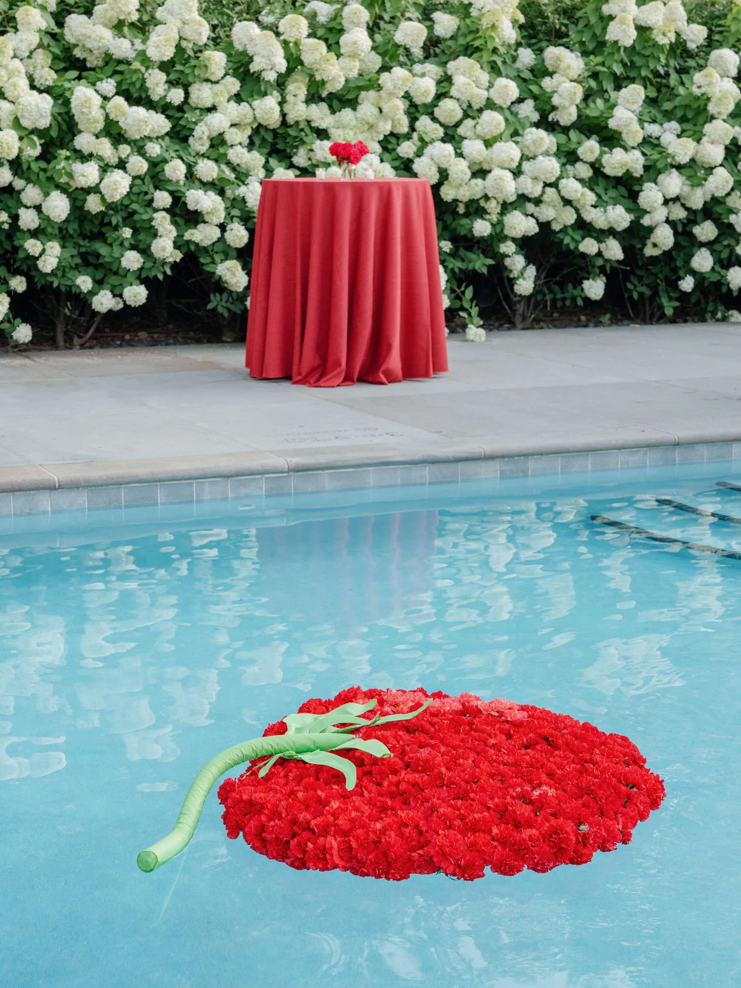 A round red carnation wreath floating in the pool at Valley Rock Inn in Sloatsburg, photographed by Jenny Fu.