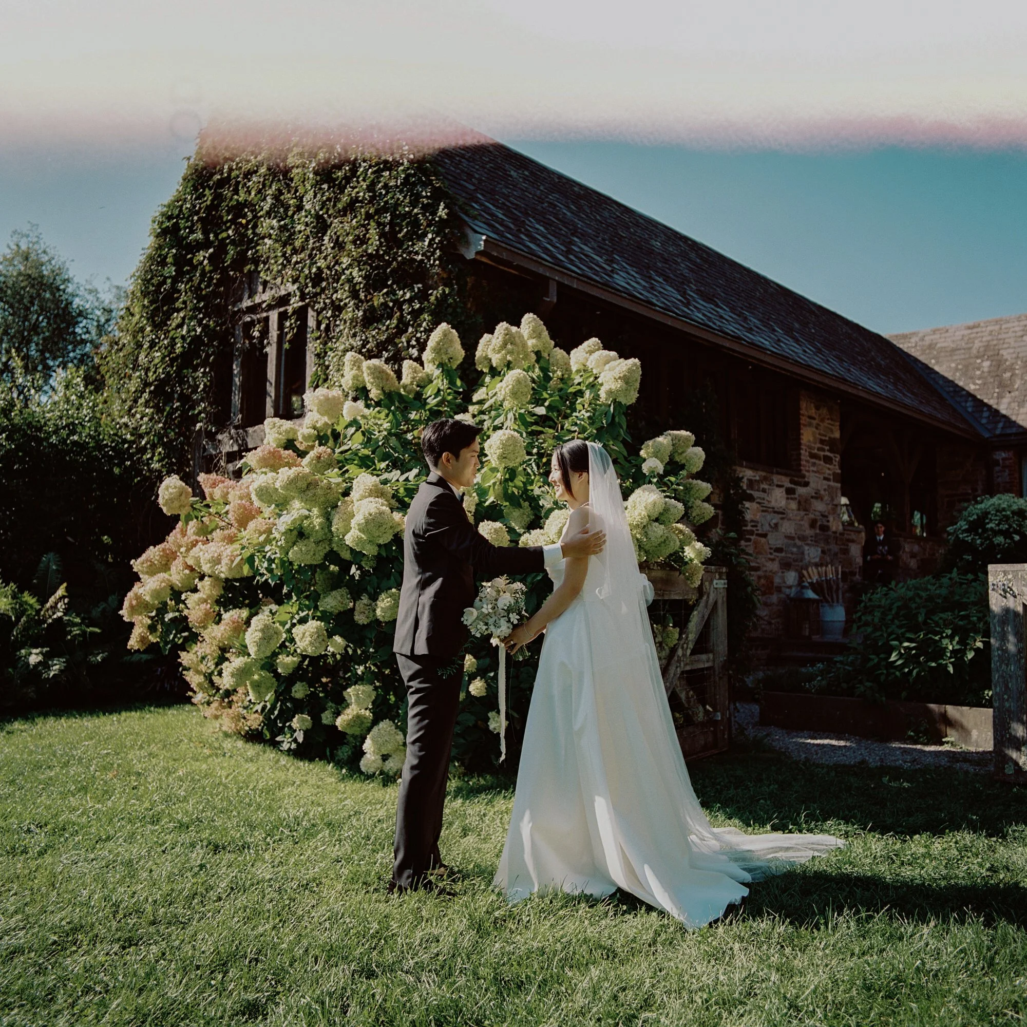 LRL-127-couple-first-look-by-hydrangeas-outside-stone-house-blue-hill-at-stone-barns-jenny-fu.jpg
