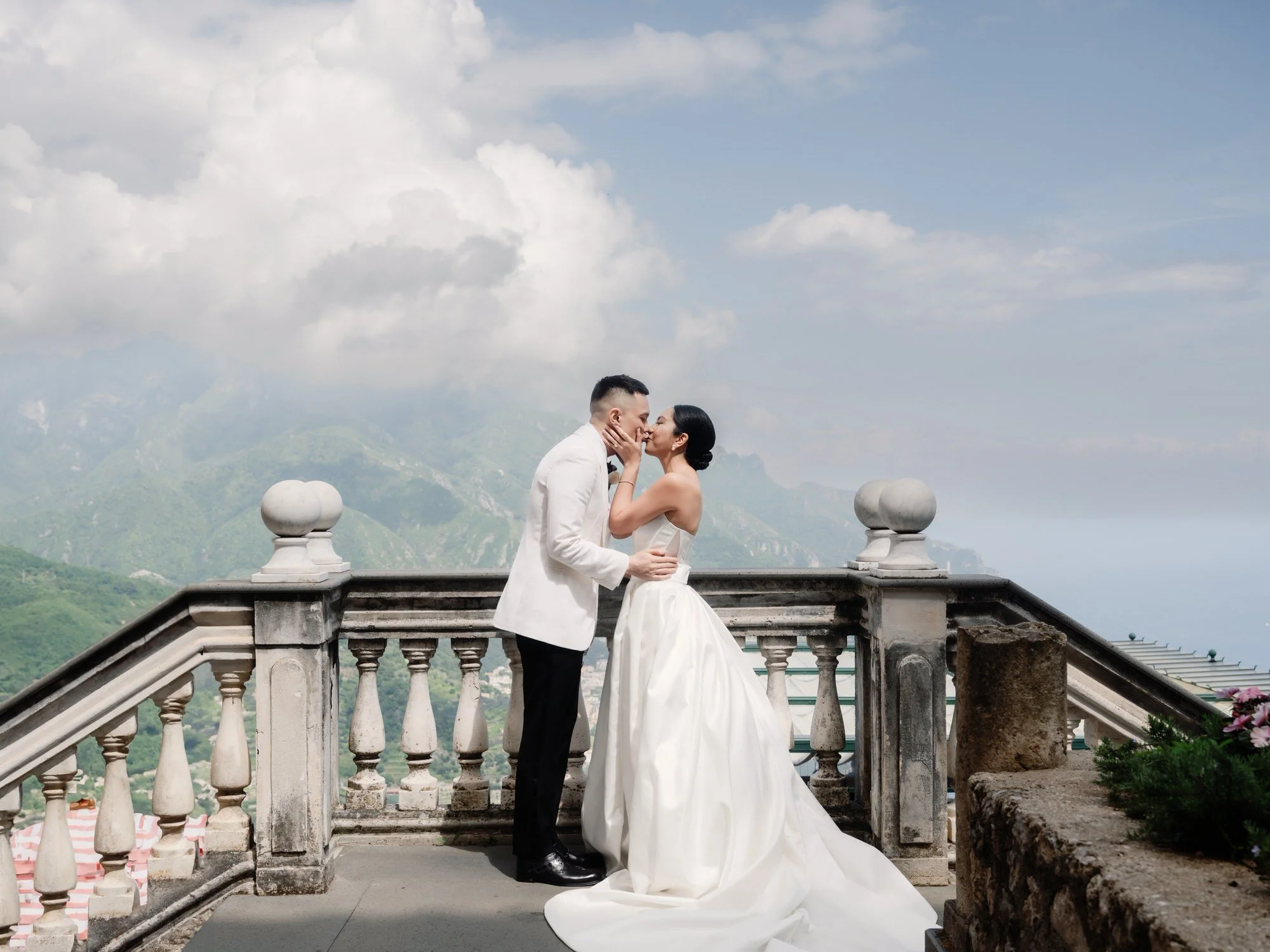 Bride and groom sharing a tender kiss during their first look on the terrace overlooking the Amalfi Coast at Caruso, A Belmond Hotel in Ravello, Italy, photographed by Jenny Fu.