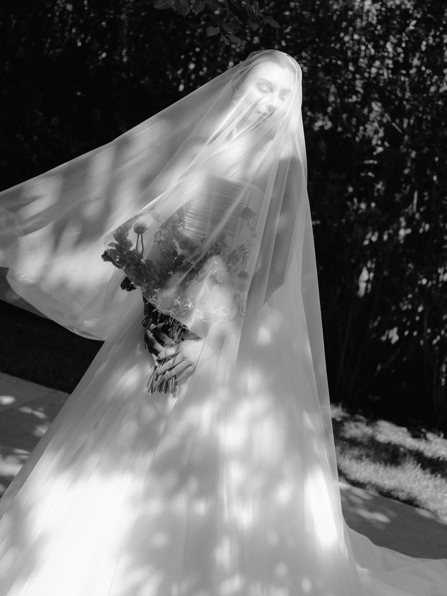 Bride beneath a flowing veil with dappled light on the terrace at Valley Rock Inn, Sloatsburg, NY, photographed by Jenny Fu.