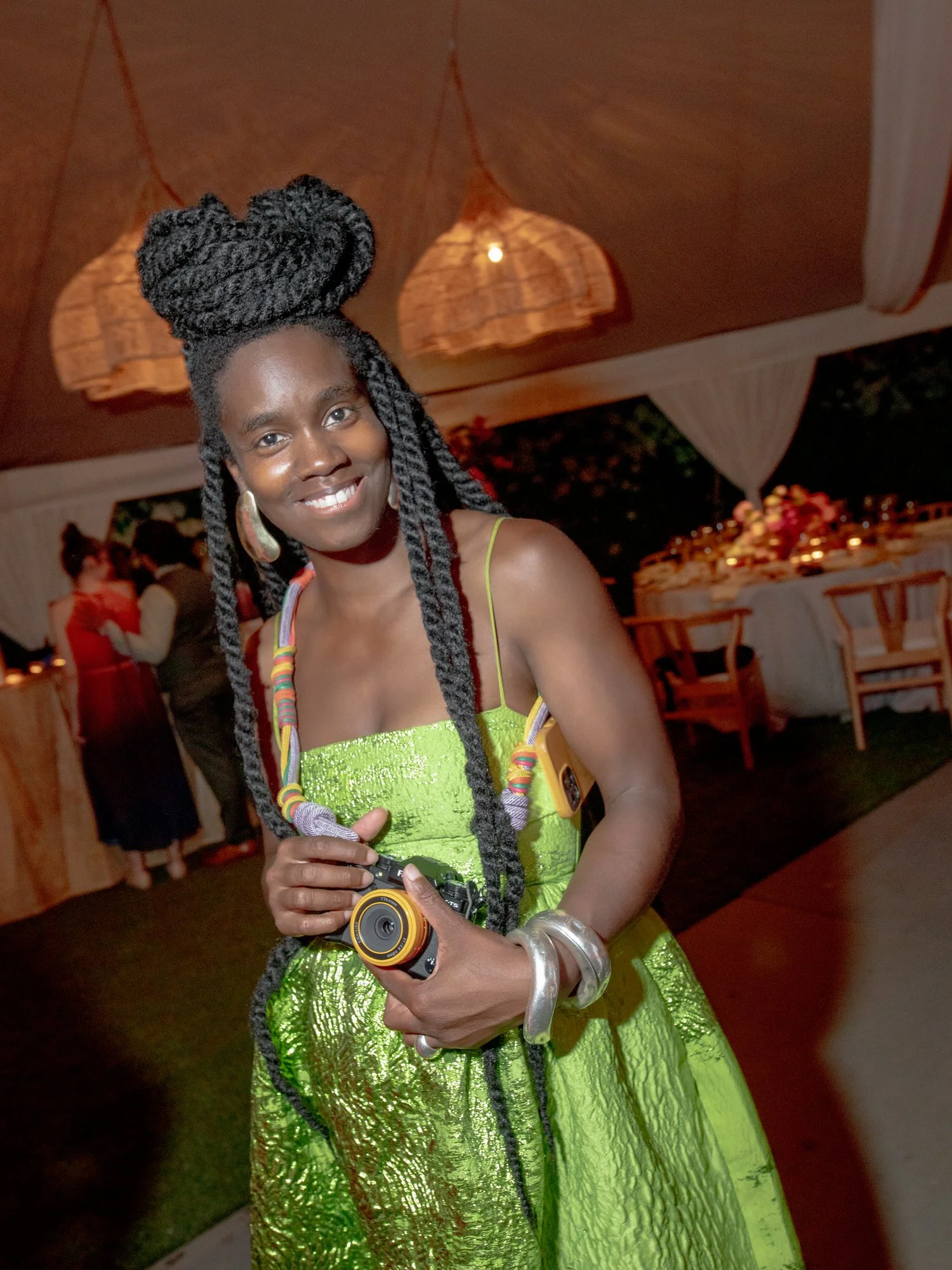 Guest in a striking green metallic dress holding a camera during the evening celebration at Valley Rock Inn in Sloatsburg, photographed by Jenny Fu.