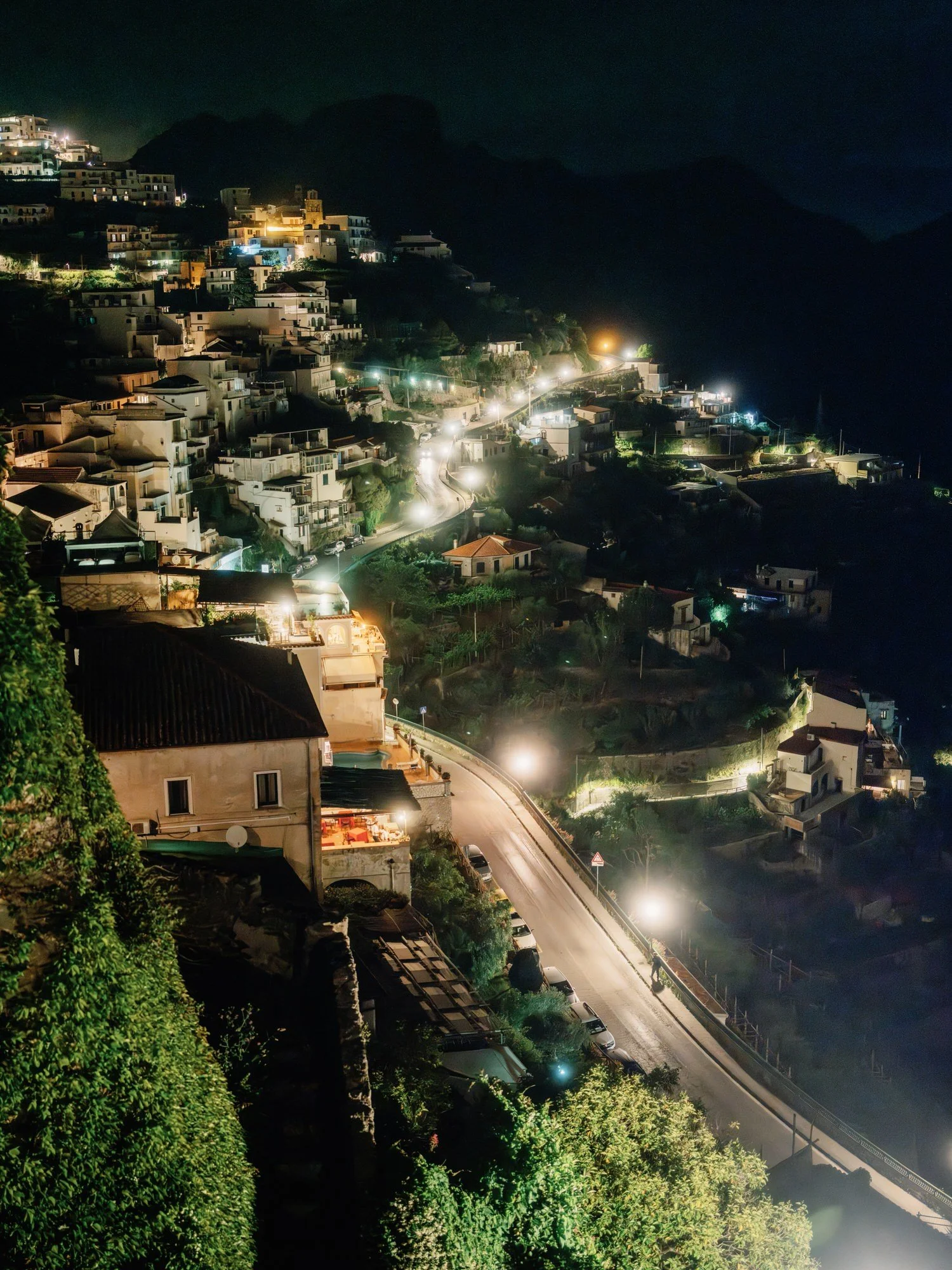 Night view of the winding streets and glowing lights of Ravello overlooking the Amalfi Coast, photographed by Jenny Fu.
