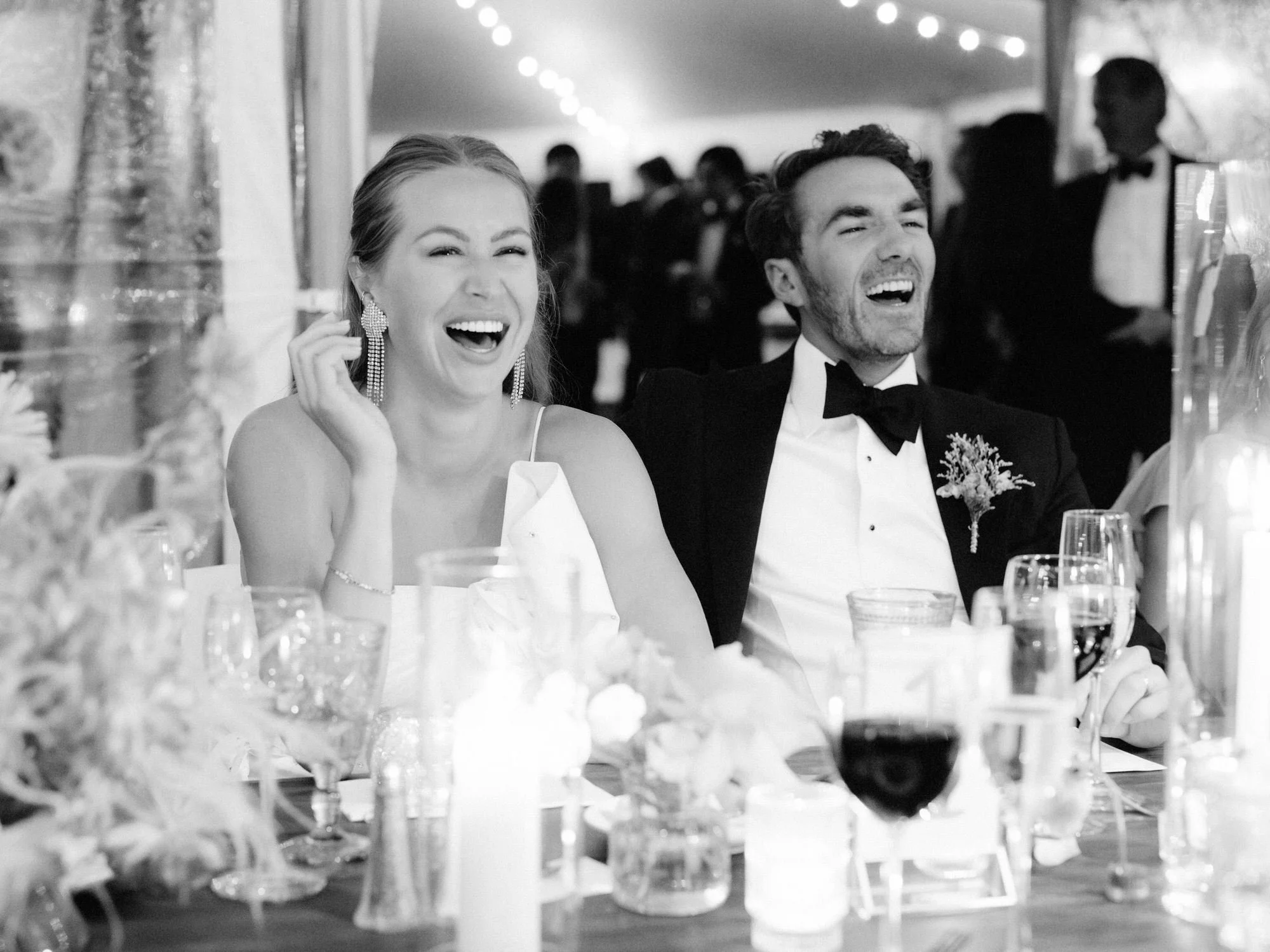 Olivia and Jack laugh together at their candlelit reception during toasts at the Ausable Club in the Adirondacks