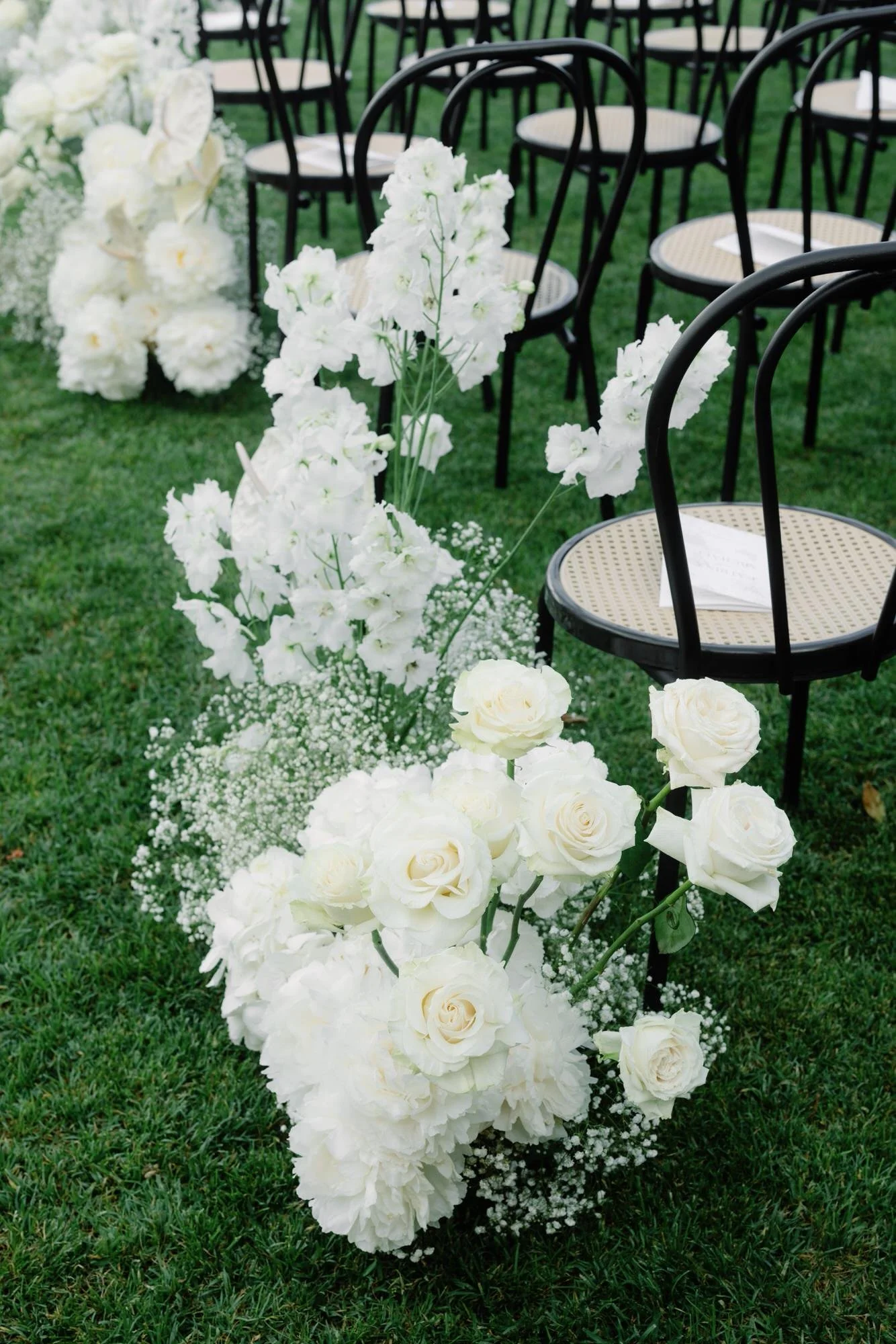 White roses, hydrangeas, and baby’s breath line the aisle during the ceremony setup at Caruso, A Belmond Hotel in Ravello, Italy, photographed by Jenny Fu.