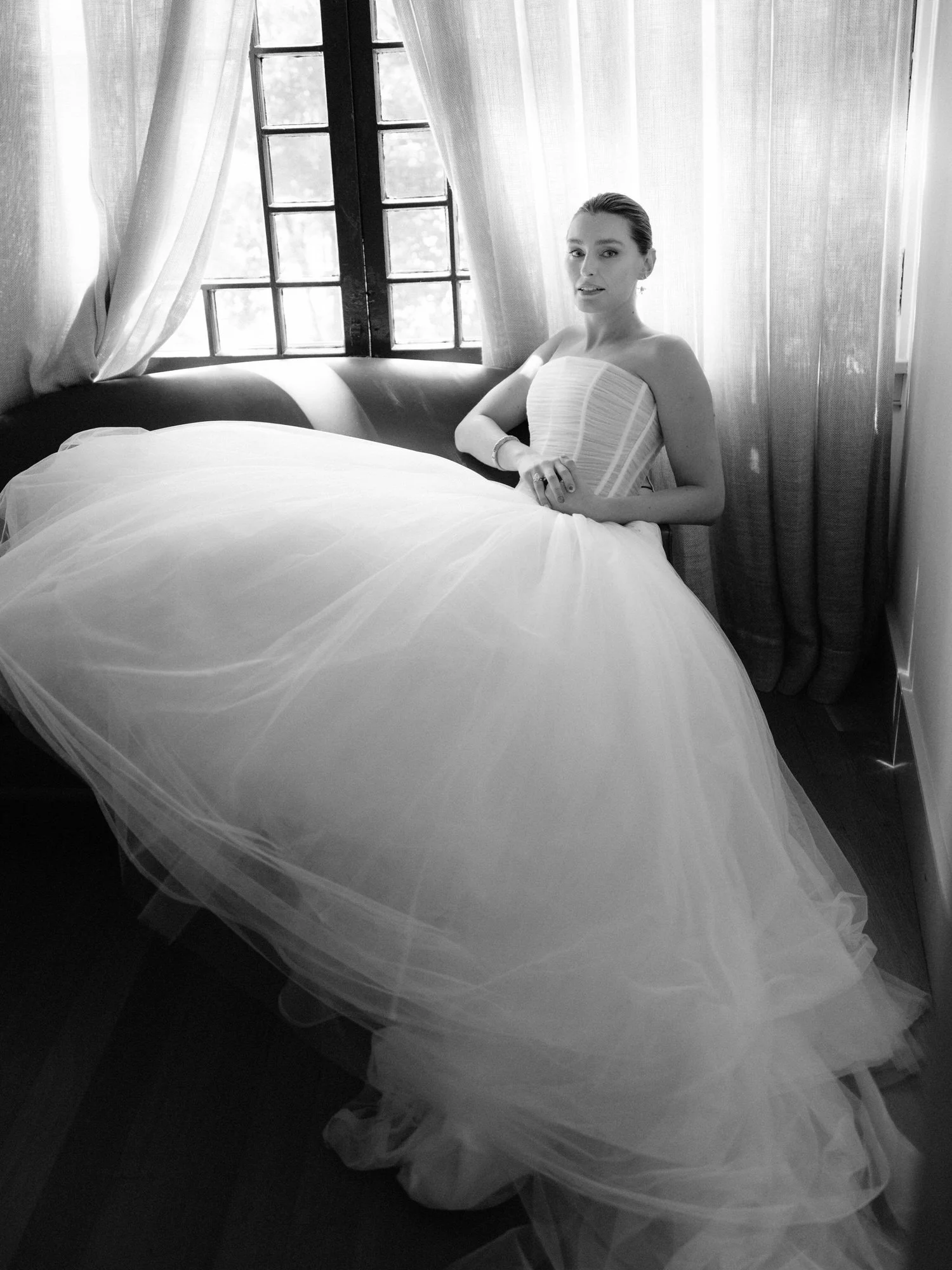 Bride relaxed on a sofa in her ballgown in a quiet black and white portrait at Valley Rock Inn in Sloatsburg, photographed by Jenny Fu.