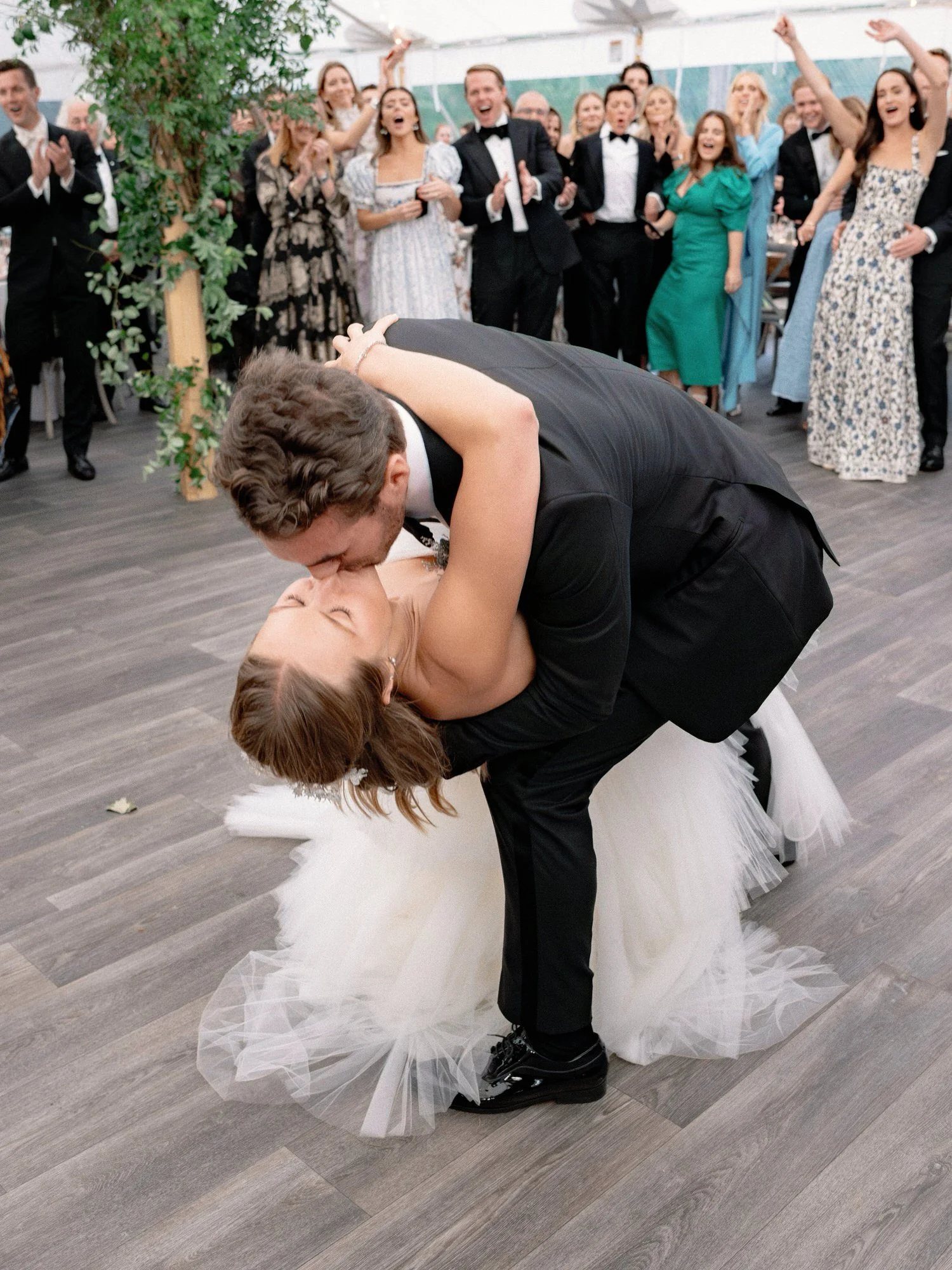 Groom dipping bride for a dramatic kiss during their first dance at Ausable Club wedding
